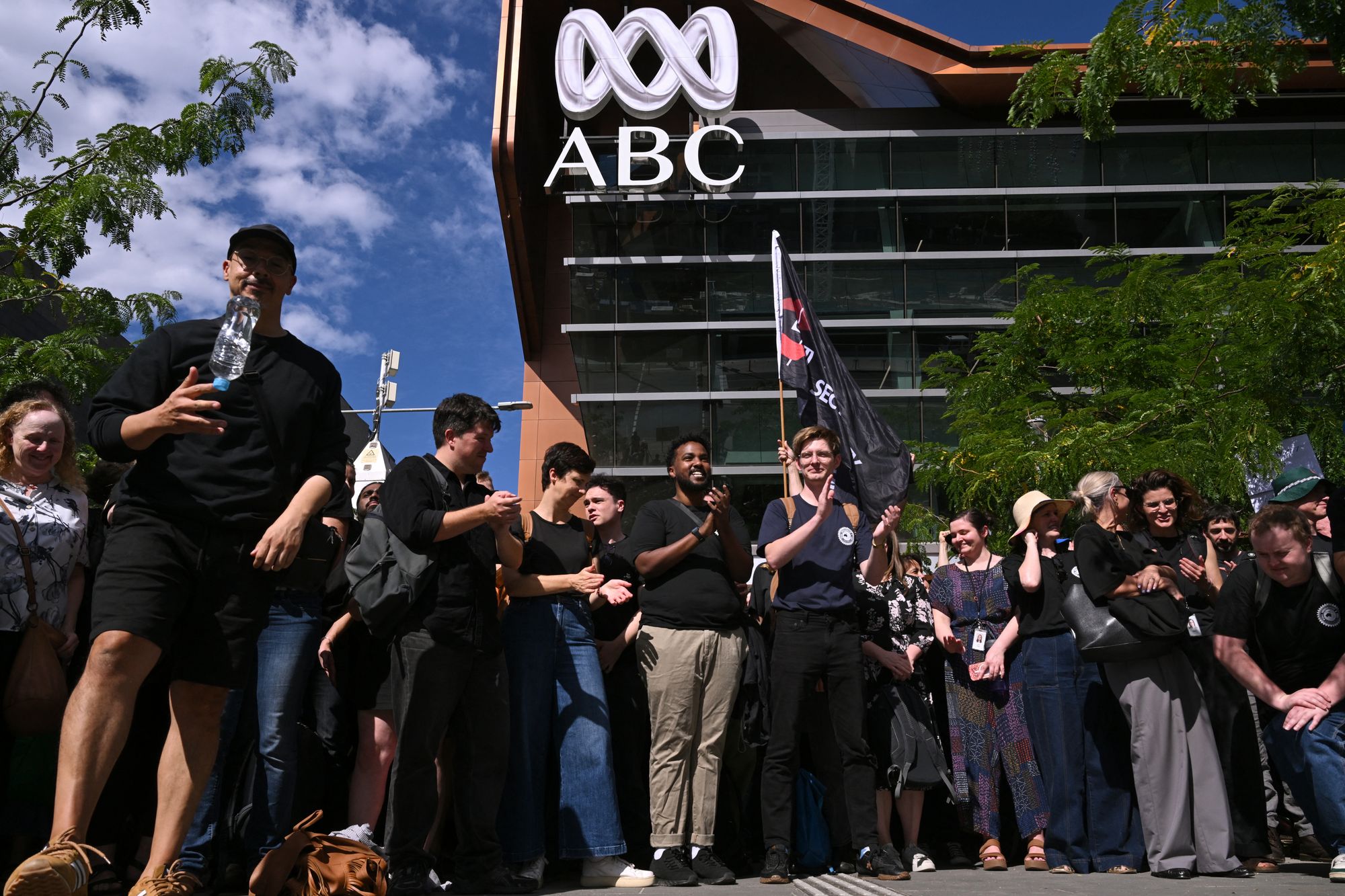 Journalists and staff walk out of the Australian Broadcasting Corporation (ABC) headquarters on strike demanding better pay and protections to stop artificial intelligence taking their jobs, in Melbourne