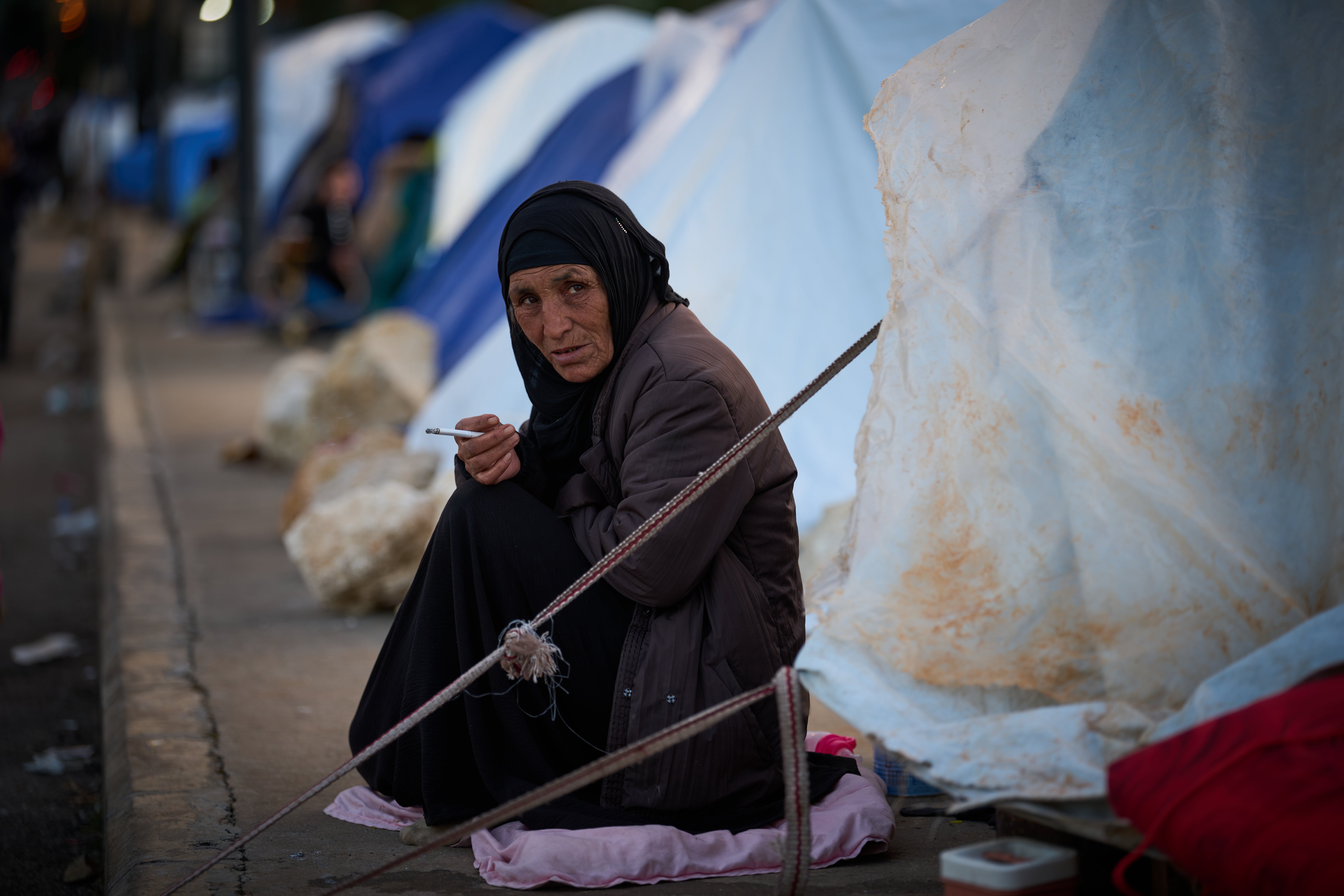 A woman who fled Israeli strikes in southern Lebanon sits outside a tent used as a shelter in Beirut