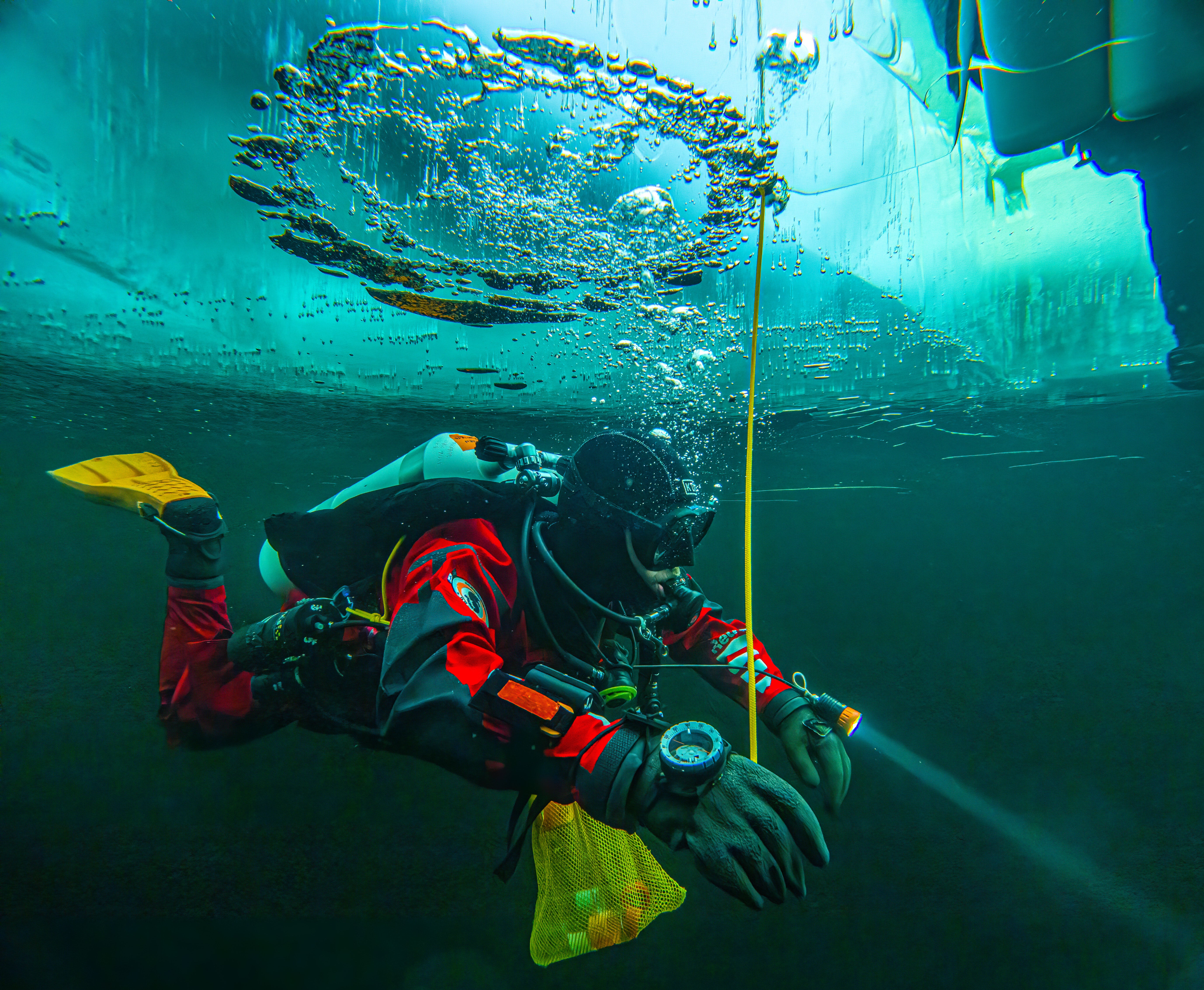 A diver swims under the ice during a Polar Scientific Diving class in Kilpisjärvi, Finland