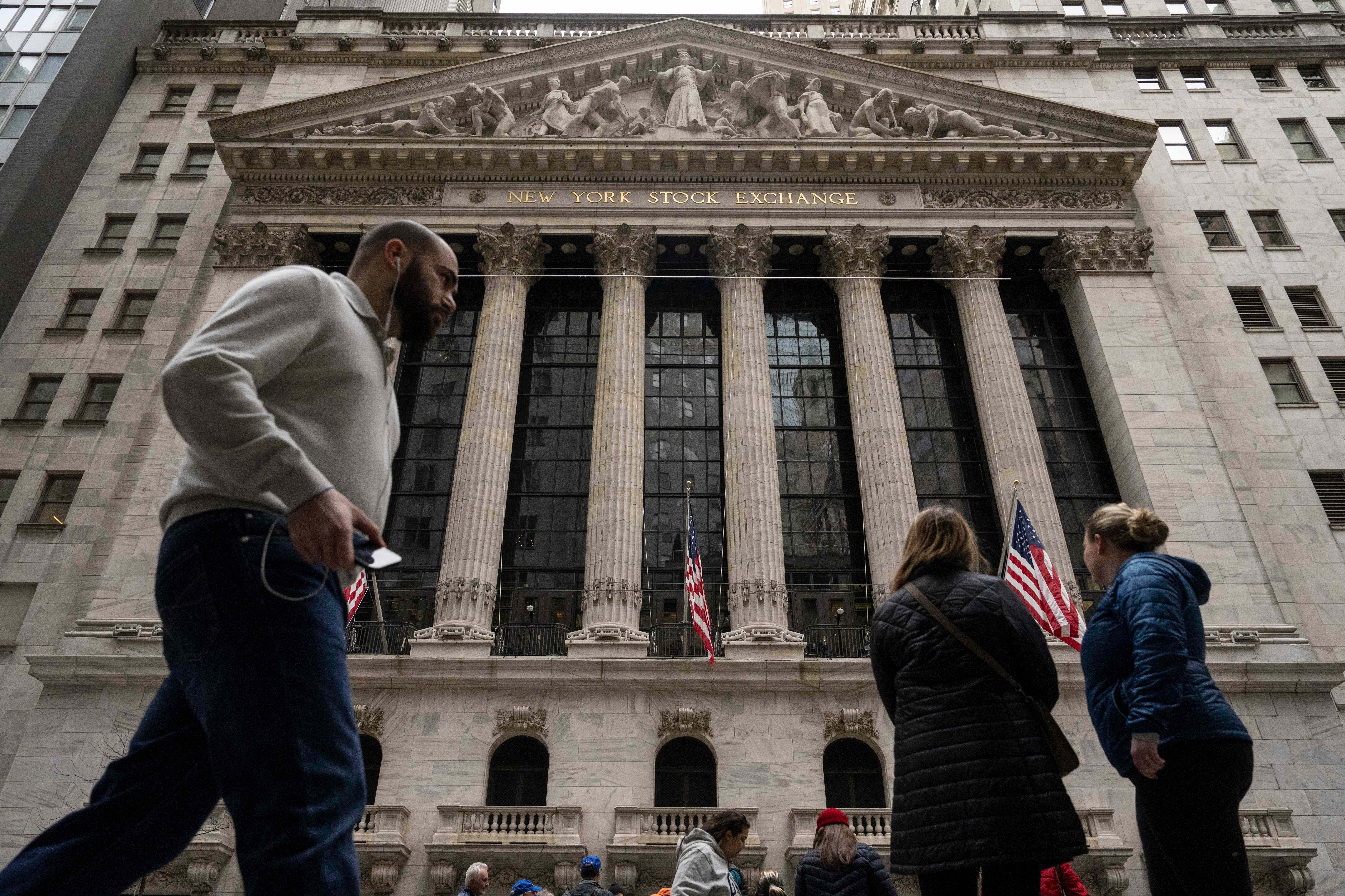 People walk past the New York Stock Exchange