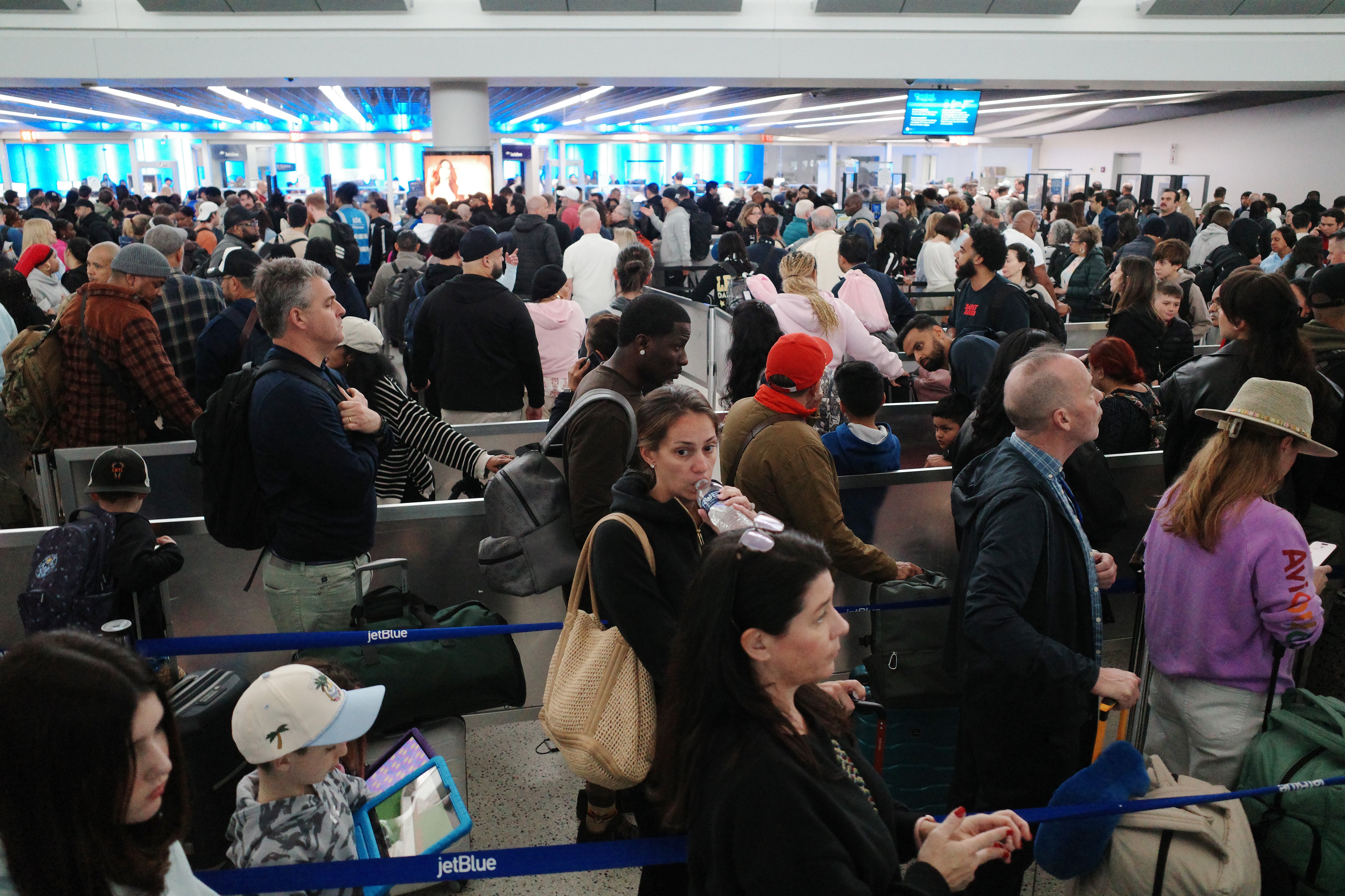 Travelers wait in line to go through security in Terminal 5 at John F. Kennedy International Airport on March 27, 2026 in New York