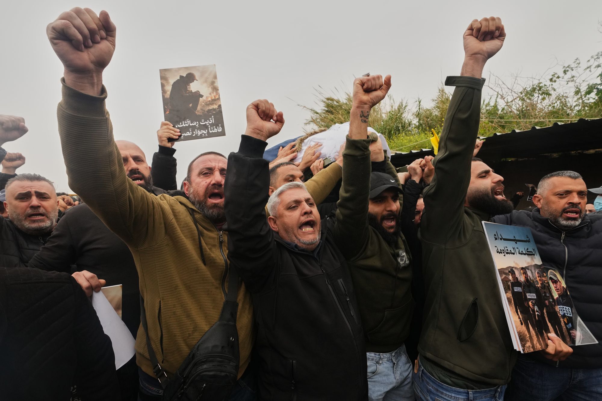 Mourners chant slogans as they carry the coffins of Hezbollah's Al-Manar TV correspondent Ali Shoeib, Al-Mayadeen TV reporter Fatima Ftouni and cameraman Ali Ftouni, who were killed Saturday in an Israeli airstrike in southern Lebanon, during their funeral procession at a temporary cemetery in Dahiyeh, Beirut's southern suburbs, Lebanon, Sunday, March 29, 2026. (AP Photo/Hassan Ammar)