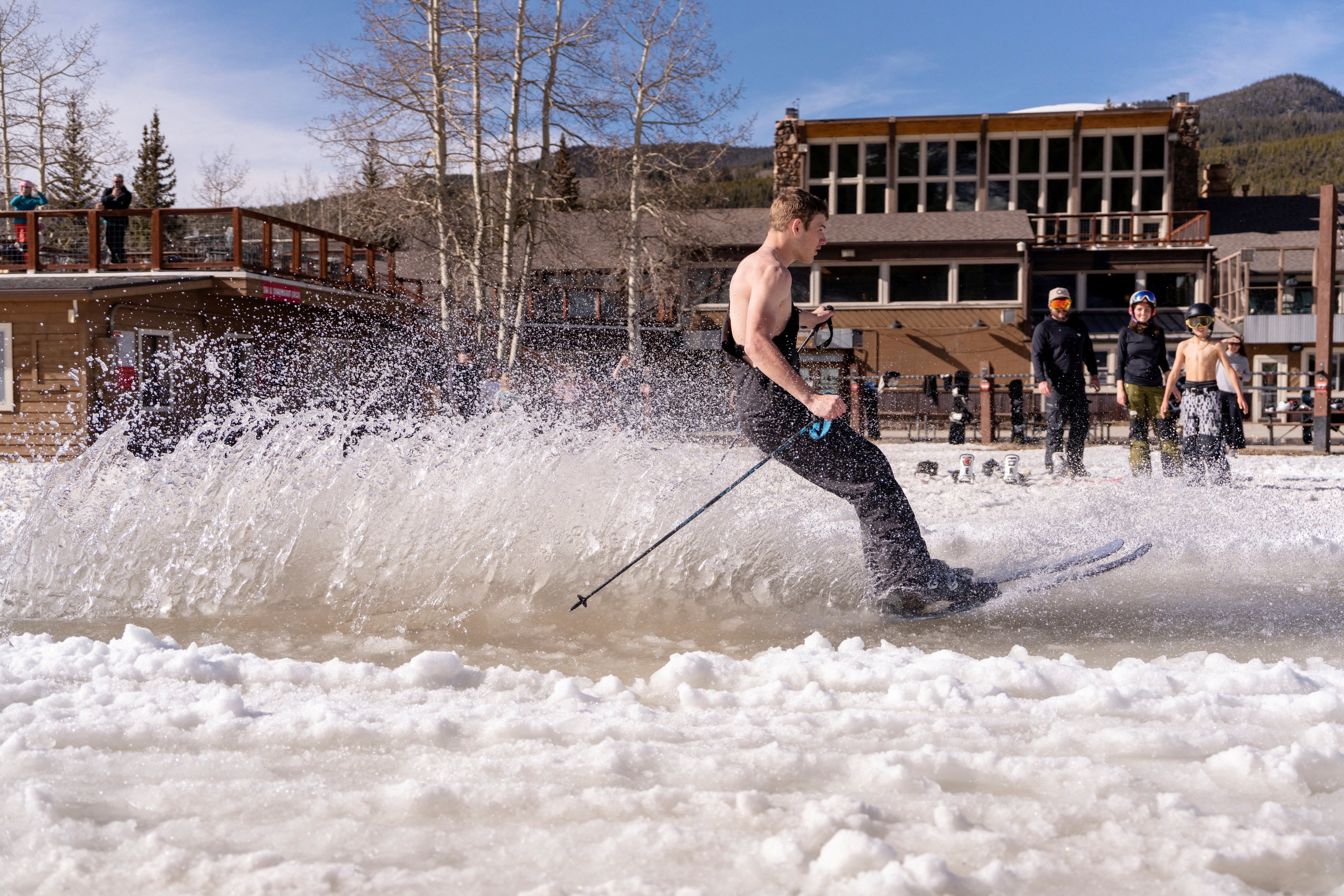 Kole Riner, 16, skis through a puddle of water at Keystone Ski Resort as temperatures reach into the mid 60s in Keystone, Colorado