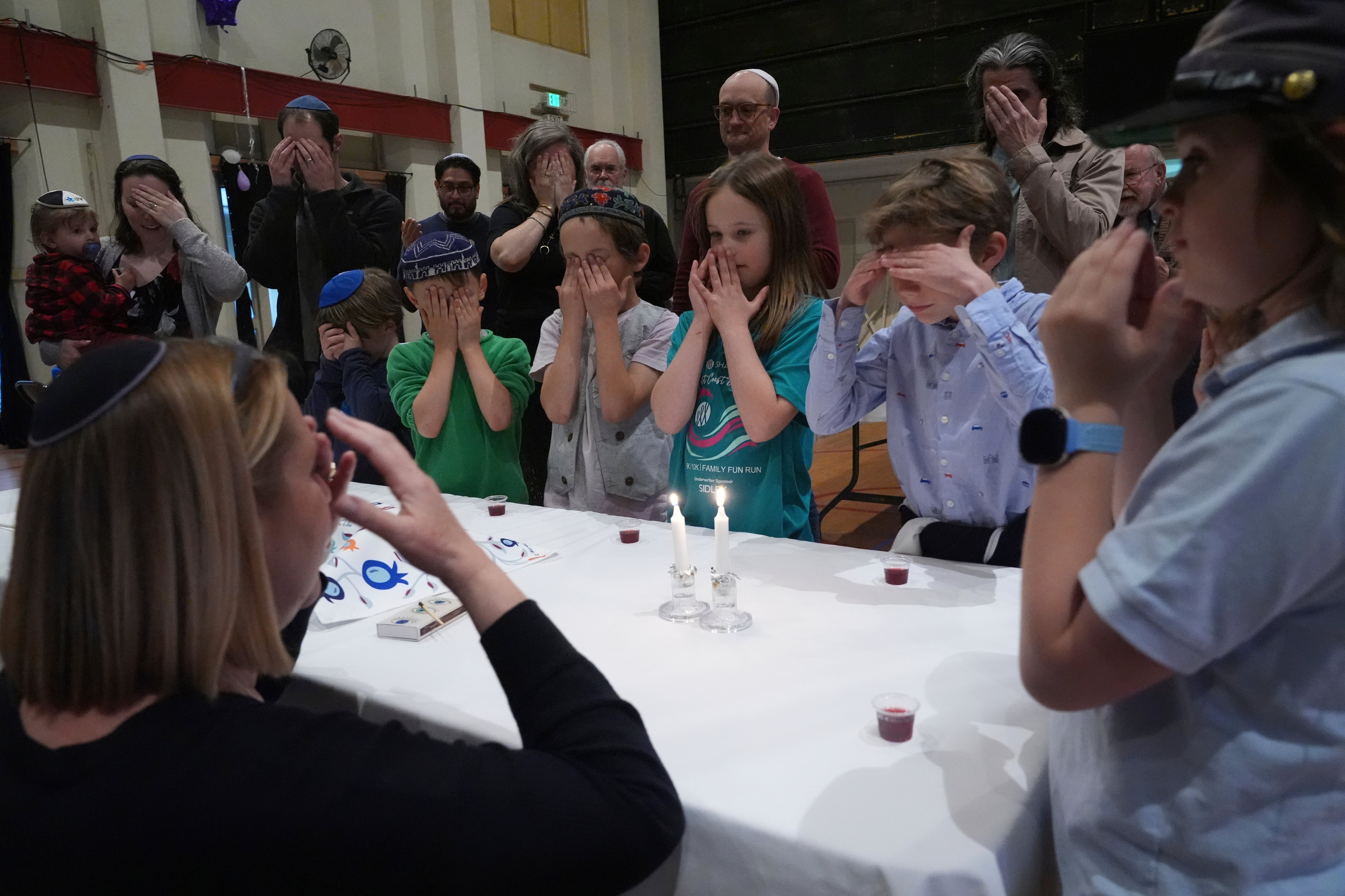 Cantor Ruth Berman Harris lights candles to celebrate Seder with congregants of the 104-year-old Pasadena Jewish Temple and Center which burned down in the Jan. 2025 Eaton fire