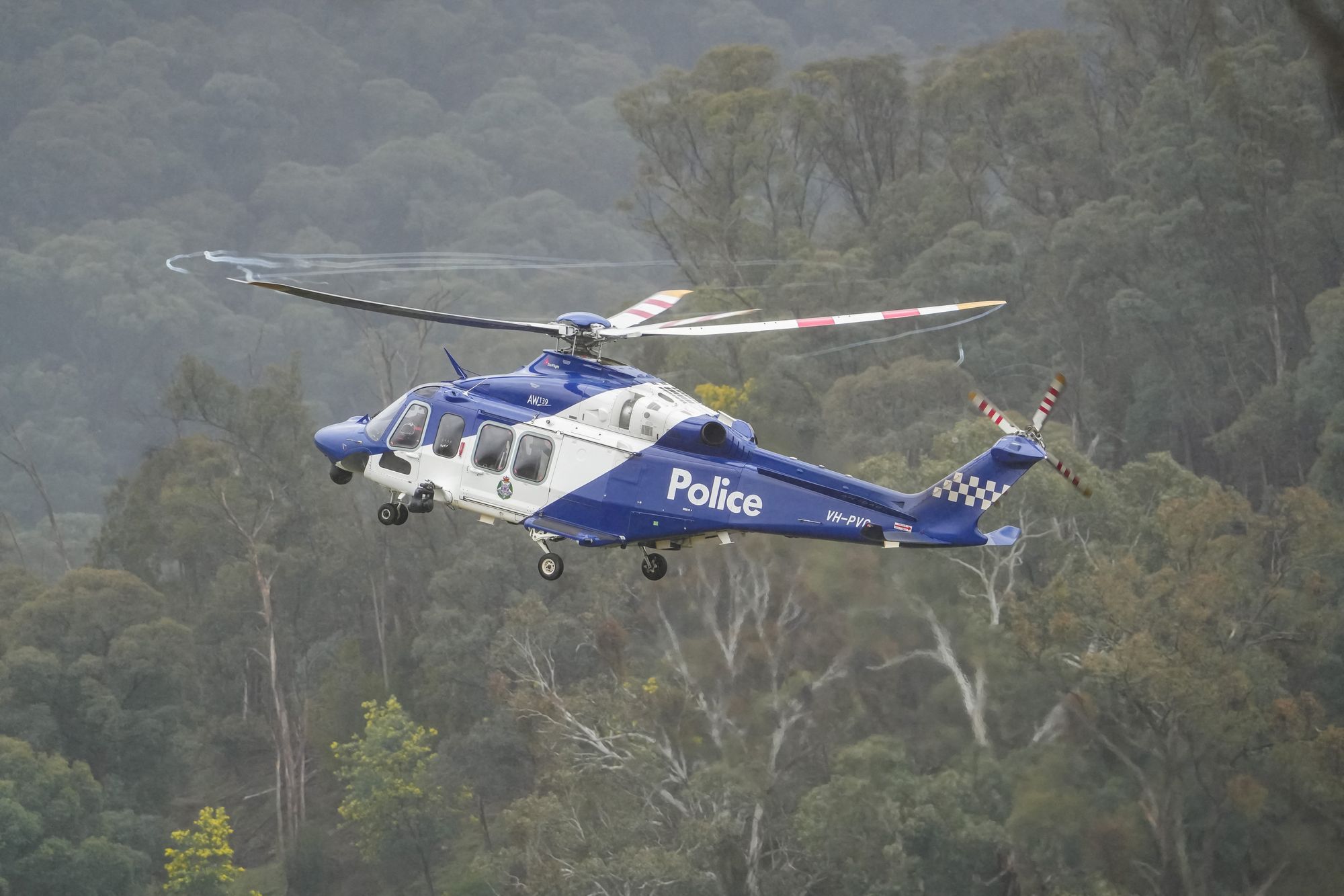 A police helicopter flies during a search for fugitive Dezi Freeman near Porepunkah, Victoria, on 28 August 2025