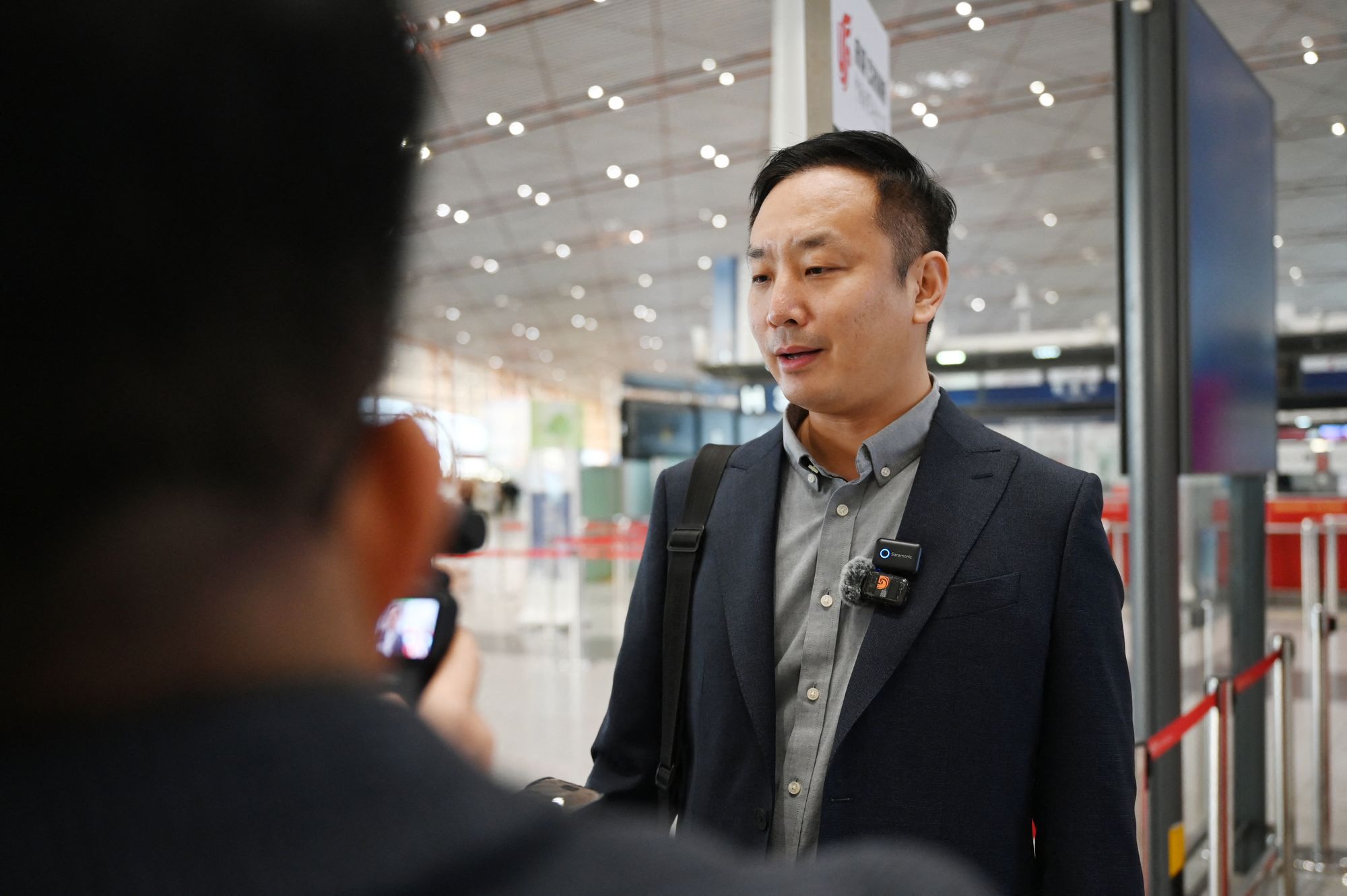 Zhao Bin, a Chinese business traveller, speaks to media after checking in for a flight to Pyongyang, North Korea at Beijing airport