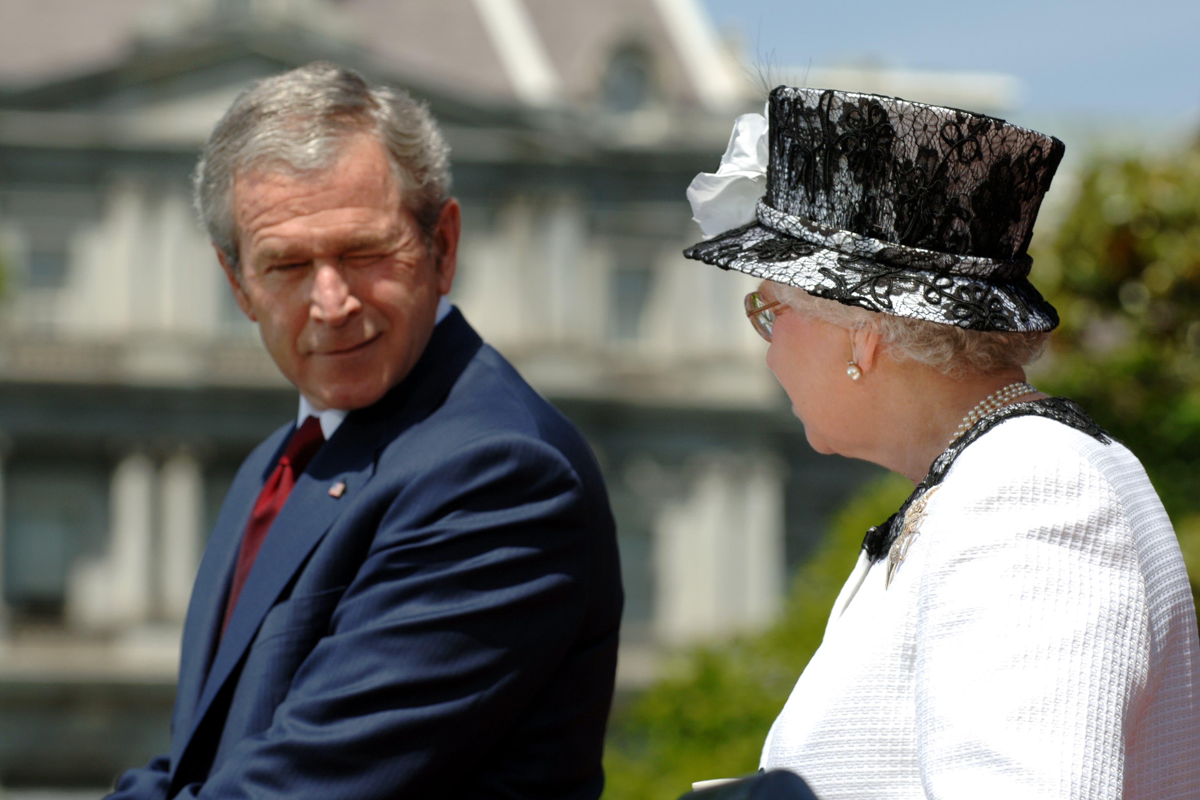 US president George W Bush winks at Queen Elizabeth II during her 2007 state visit (Fiona Hanson/PA)