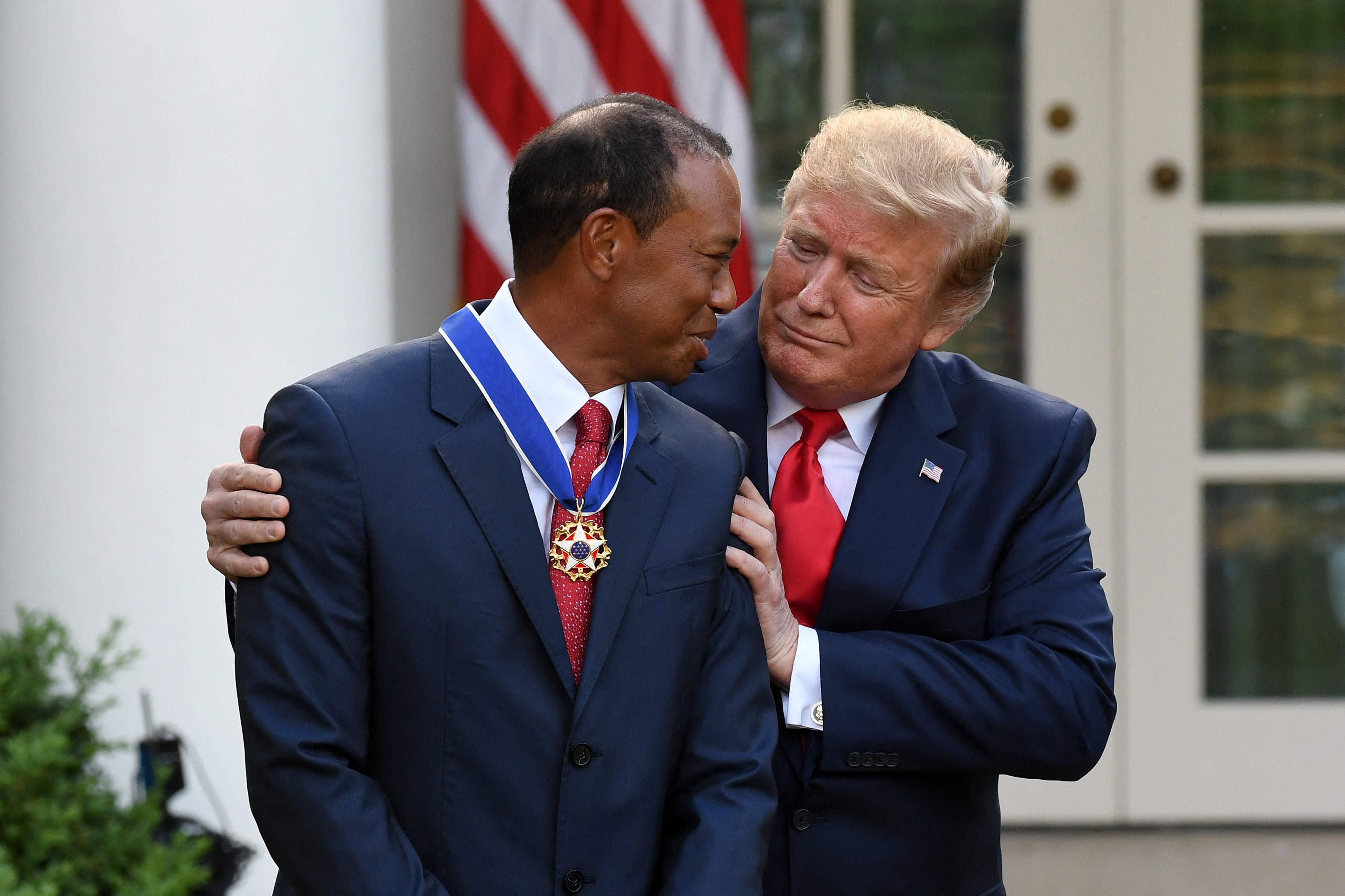 Tiger Woods (left) alongside US president Donald Trump