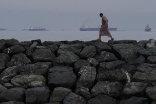 Oil tankers and cargo ships line up in the Strait of Hormuz, seen from Khor Fakkan, United Arab Emirates, March 11