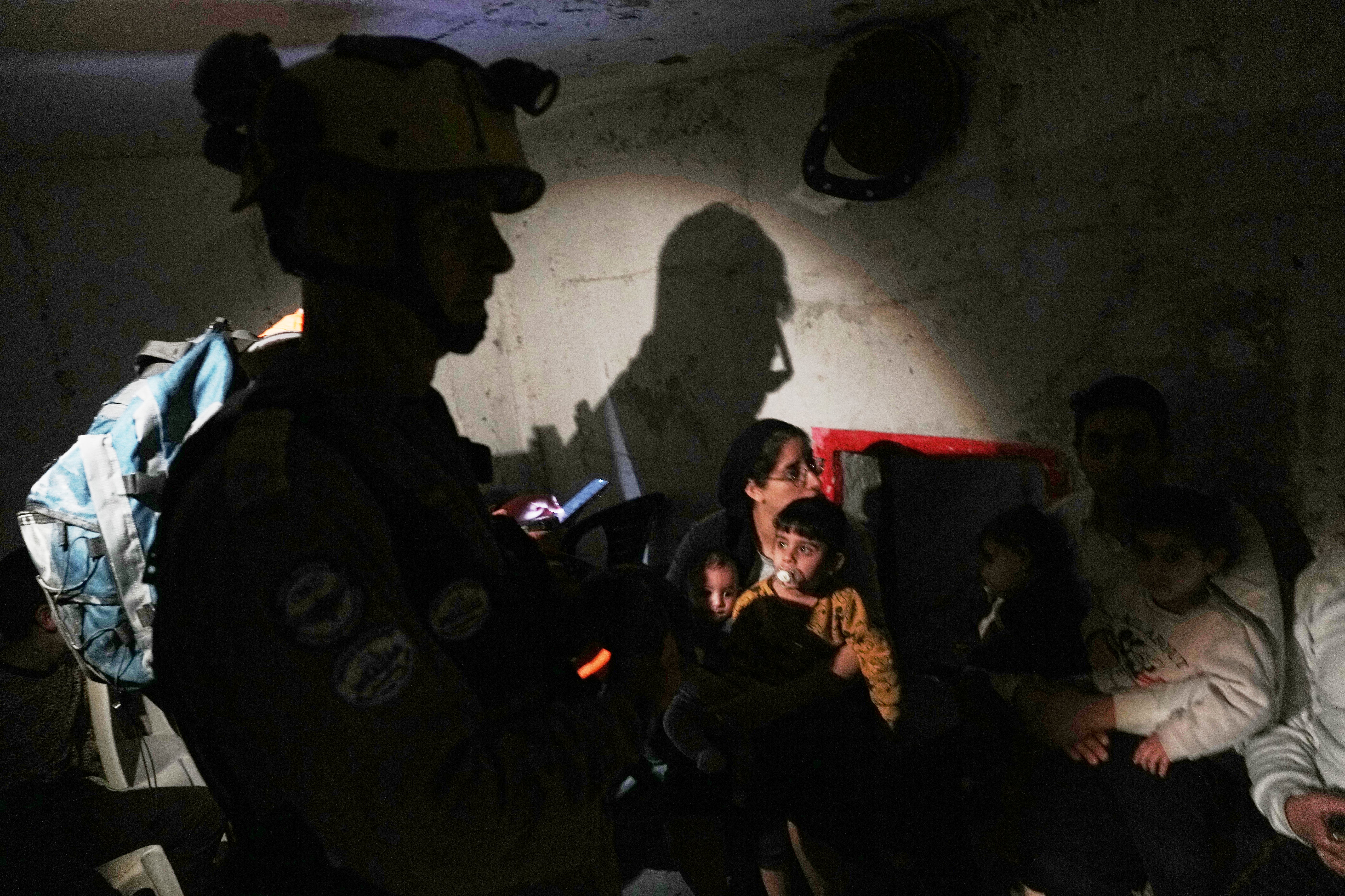 Israel's rescue teams and residents take shelter as sirens sounds next to a site struck by an Iranian missile in Bnei Brak, Wednesday, 1 April