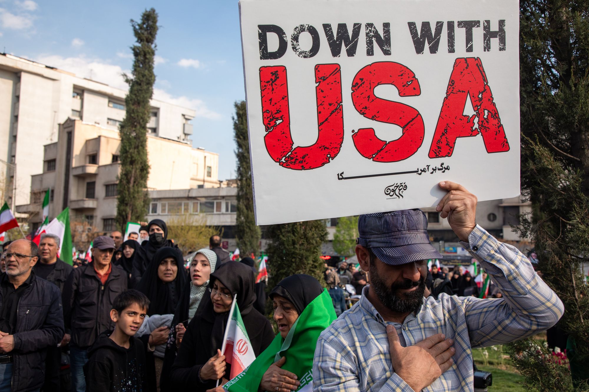 A mourner holds an anti-American sign during a funeral procession held for IRGC Navy Chief Alireza Tangsiri