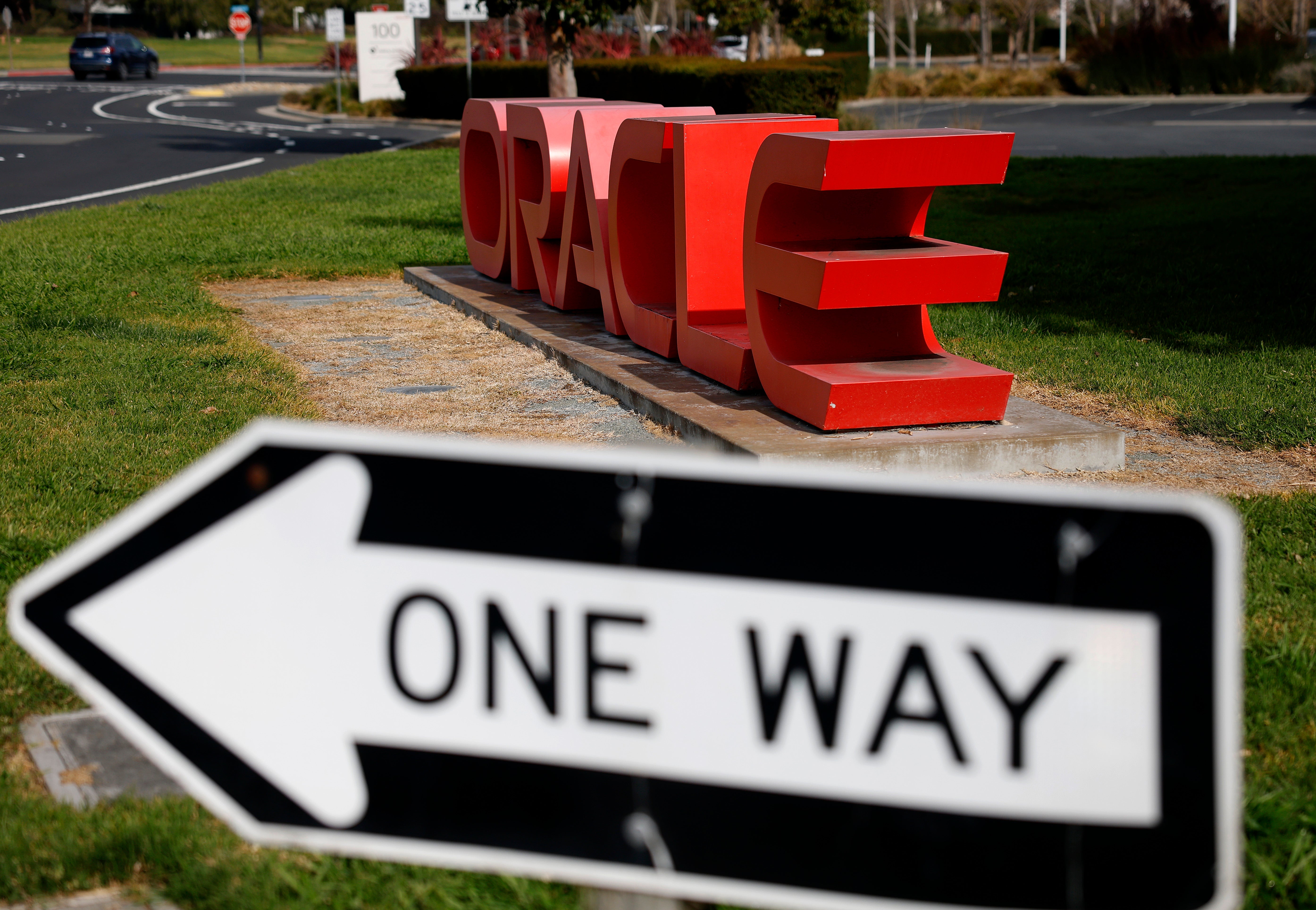 The Oracle logo is displayed in front of an Oracle campus in Redwood Shores, California