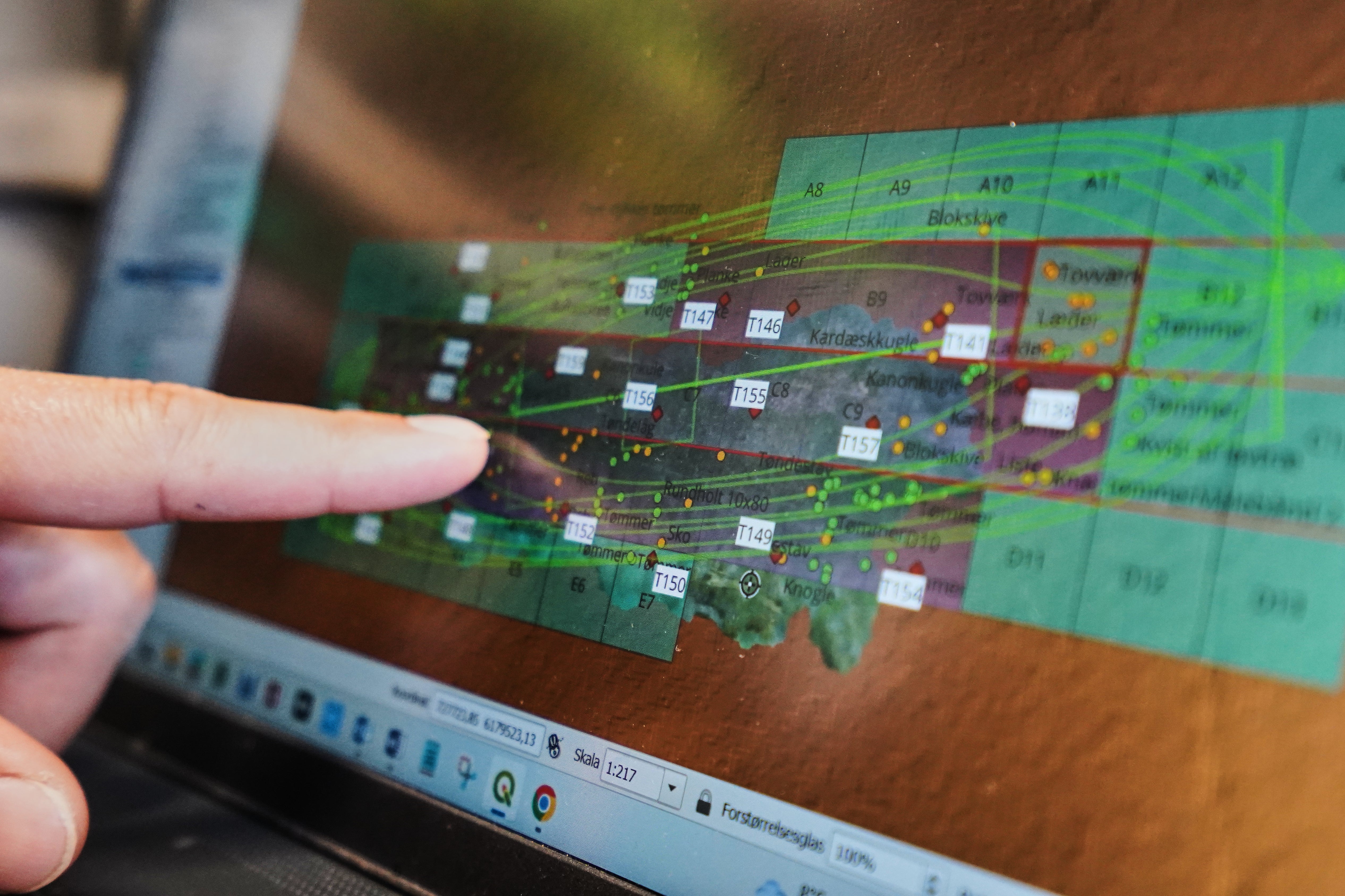 An archaeologist points to a computer screen, showing a map of the wreck of Danish flagship 