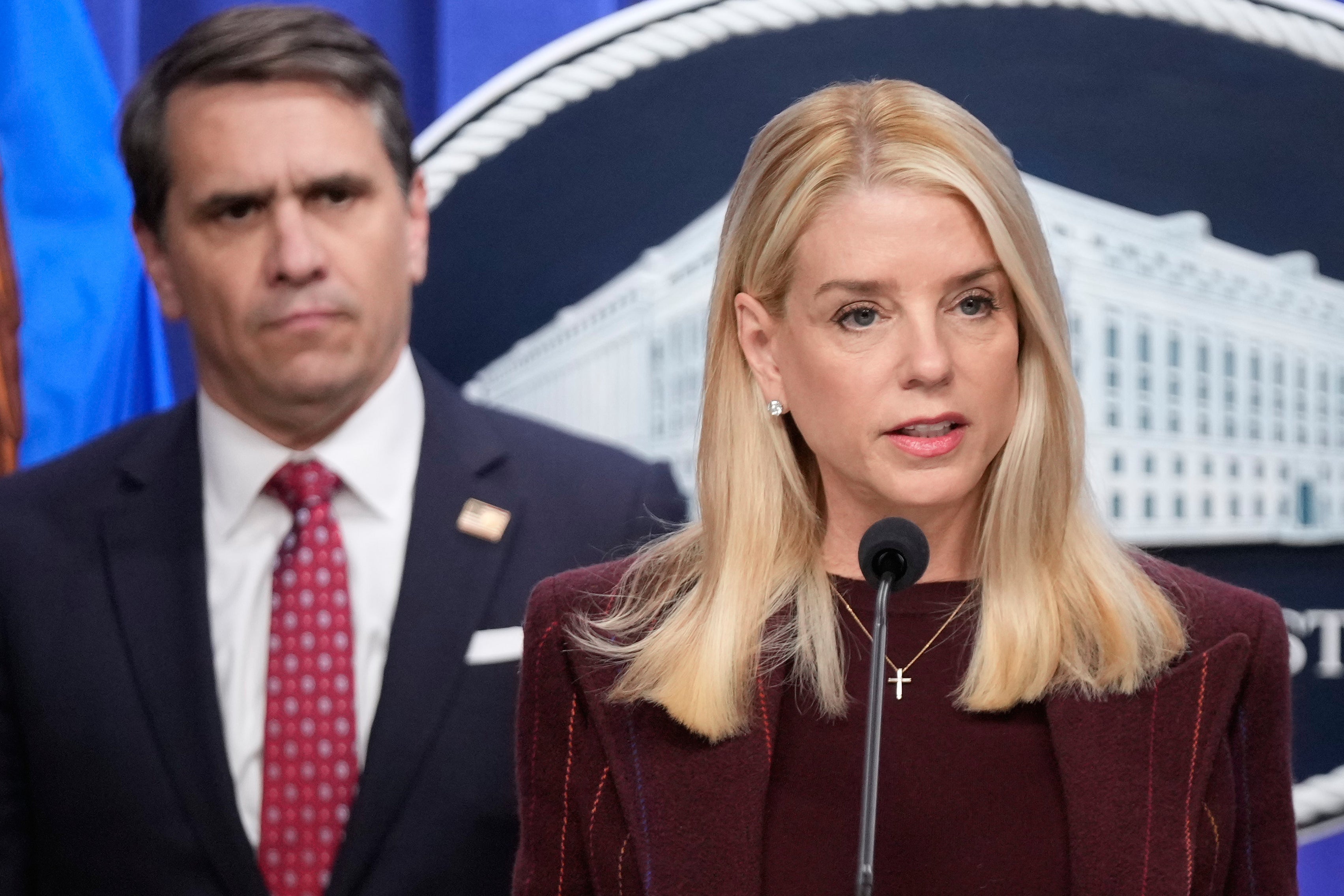 Bondi addressing reporters as then-Deputy Attorney General Todd Blanche watches from behind. Blanche became the interim U.S. Attorney General after Trump fired Bondi