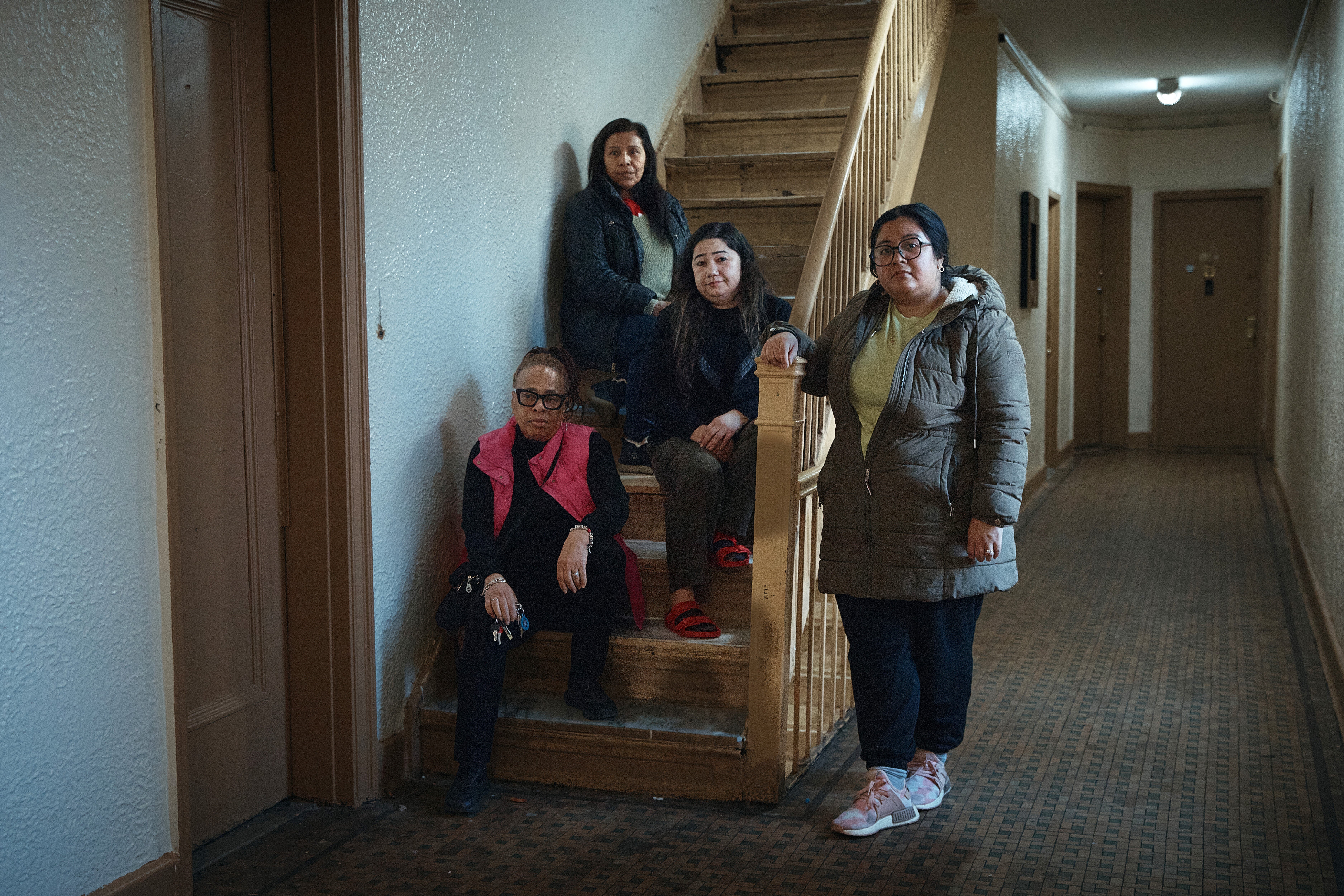 Gulhayo Yuldosheva, 33 , center right, Marina Quiroz, 65, top, pose for a portrait with other two residents in an apartment building where tenants report maintenance issues and pest infestations, in the Bronx borough of New York, Tuesday, March 17, 2026. (AP Photo/Andres Kudacki)