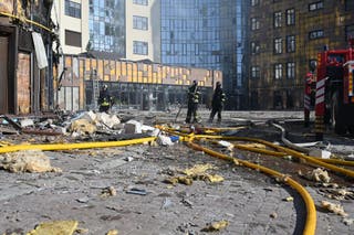 Ukrainian rescuers work in the courtyard of a damaged residential building following a drone attack in Kharkiv on 2 April 2026