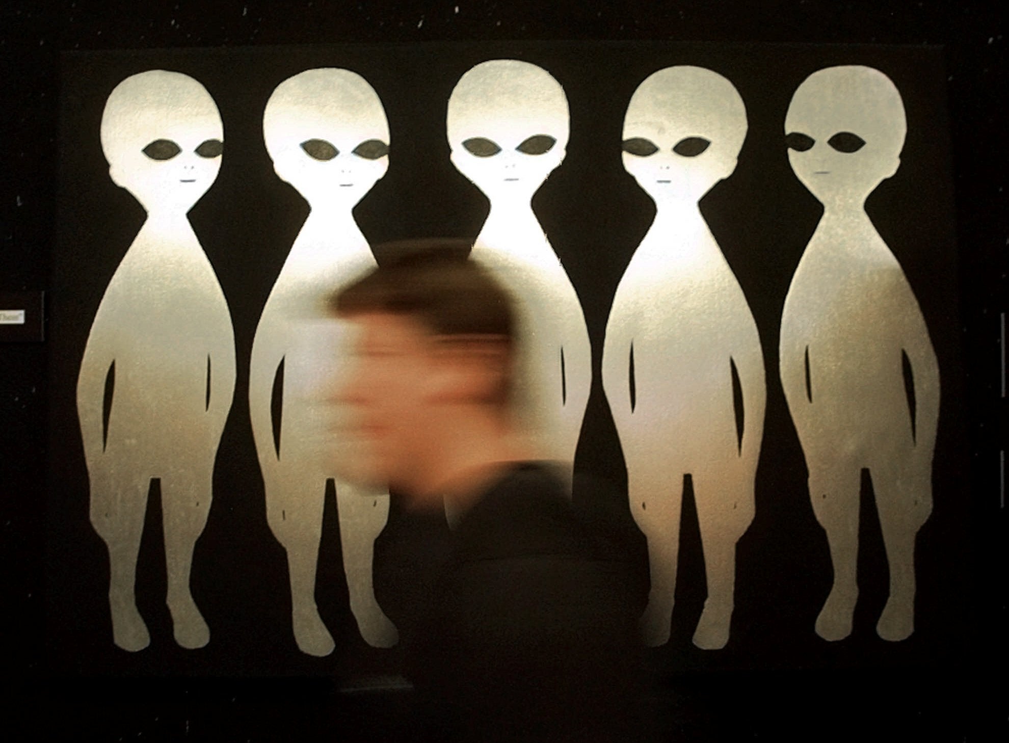 A patron passes a painting inside the International UFO Museum and Research Center in Roswell, N.M., on June 10, 1997. (AP Photo/Eric Draper, File)