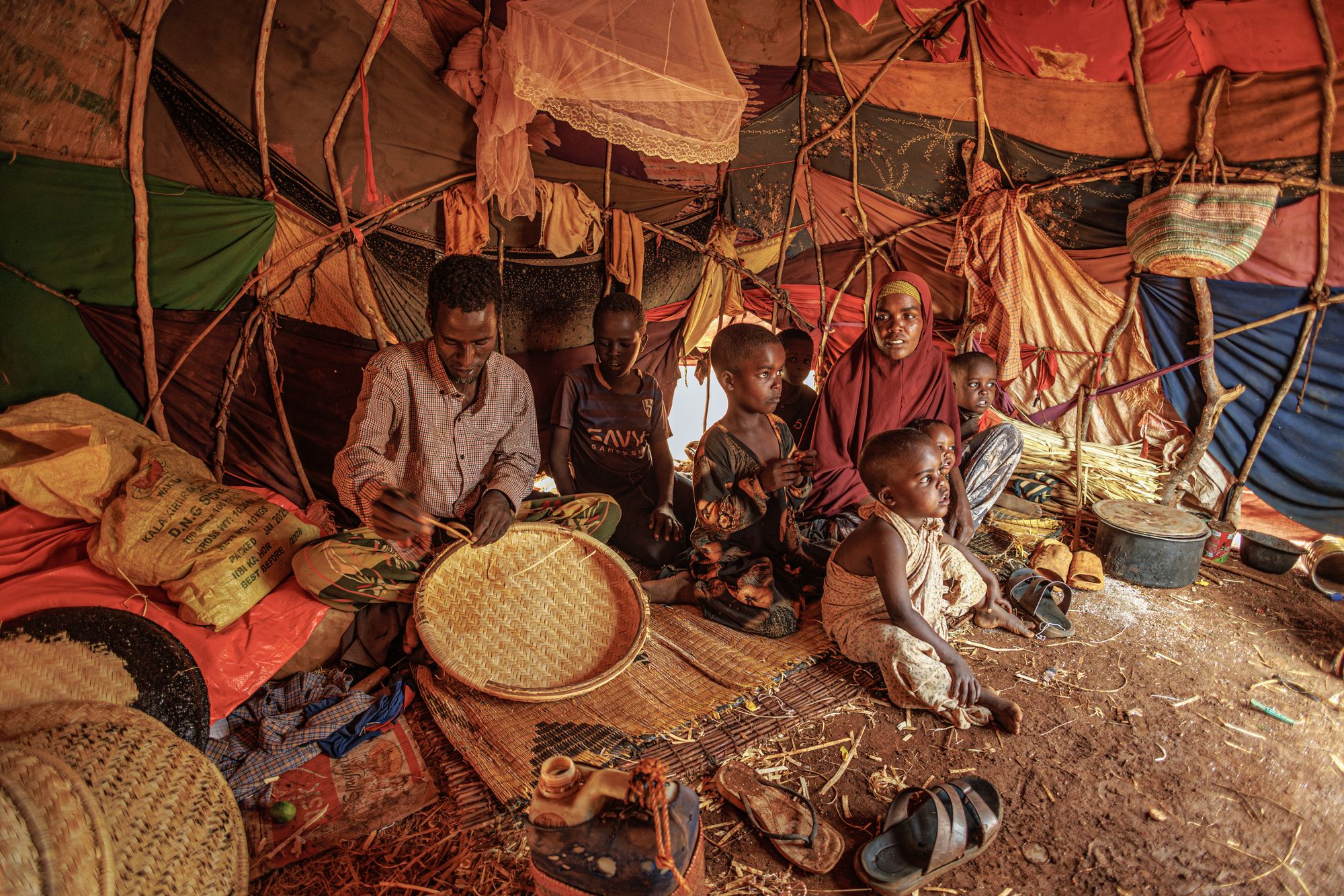 A family sits under a makeshift shelter at the Madina Internally Displaced Persons camp in Somalia (Mercy Coprs)