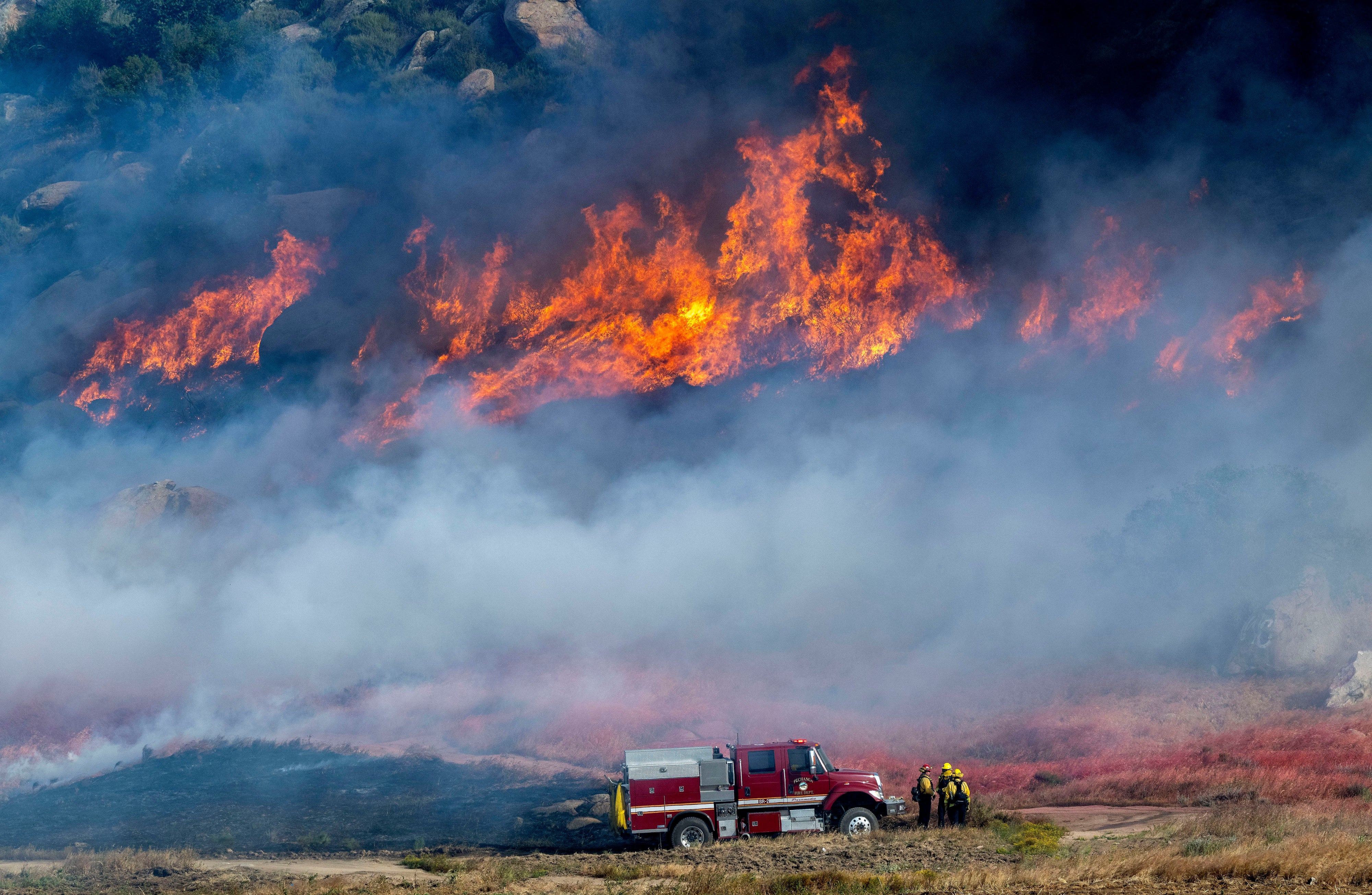 Residents were evacuated Friday as 50mph winds whipped up two separate brush fires in Southern California (AP)