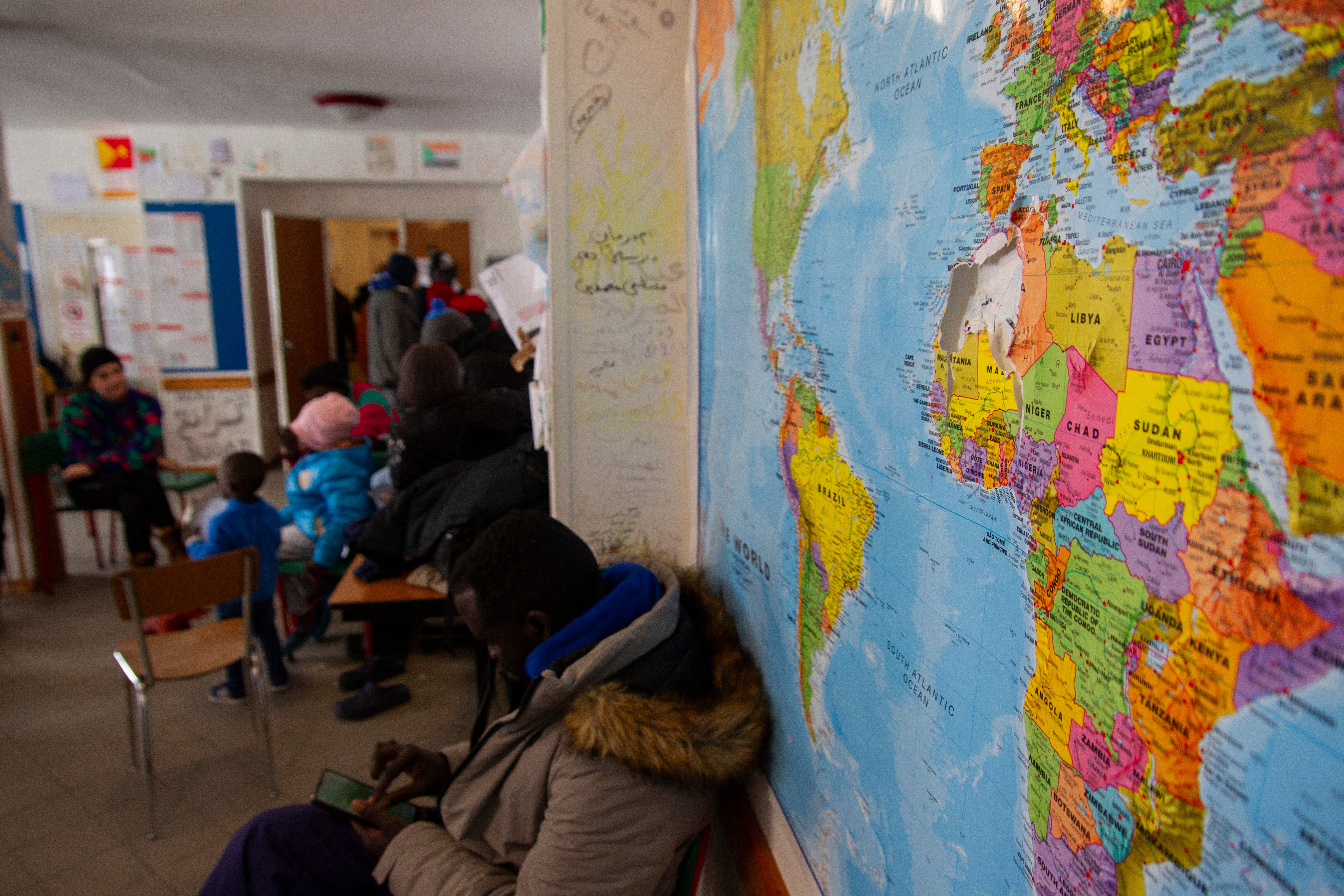 A world map hangs on a wall in the refuge s living area