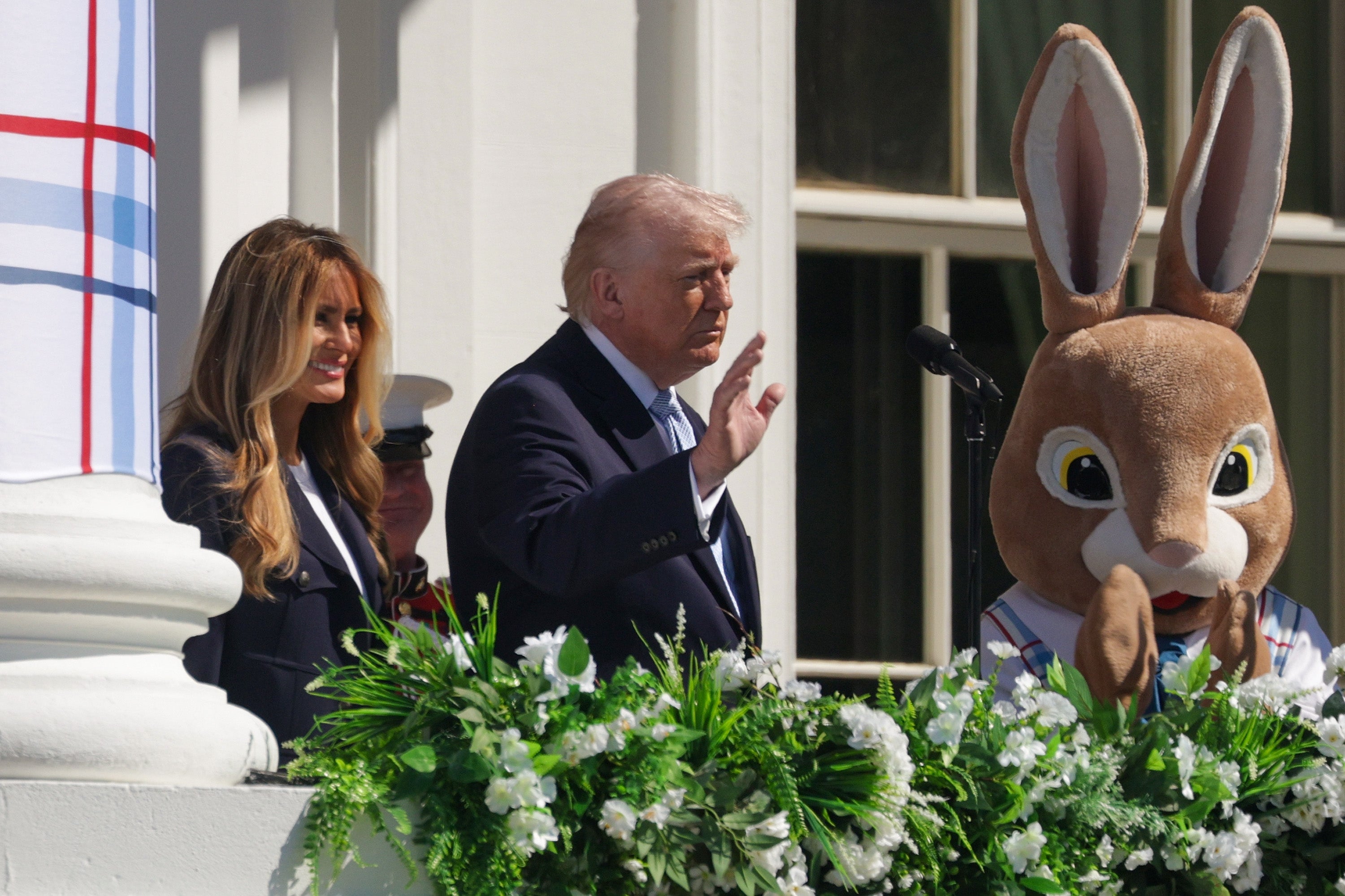 President Donald Trump, first lady Melania Trump and the Easter Bunny wave to the crowd from the annual Easter event at the White House
