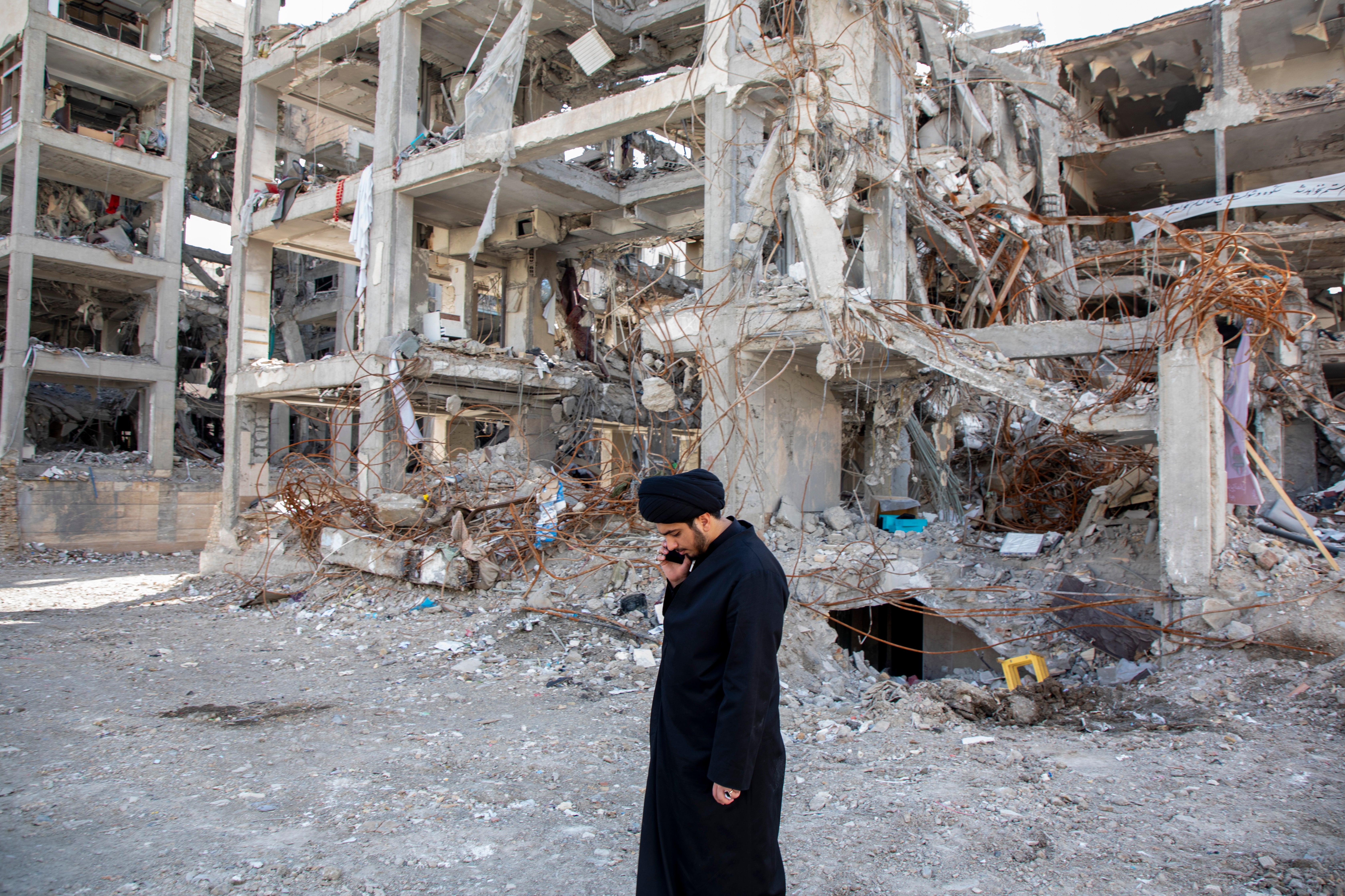 A man walks among buildings destroyed in a joint attack by Israel and the US on Monday in Tehran
