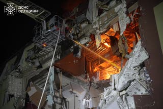 Firefighters work at the site of an apartment building hit by a Russian drone strike in Odesa