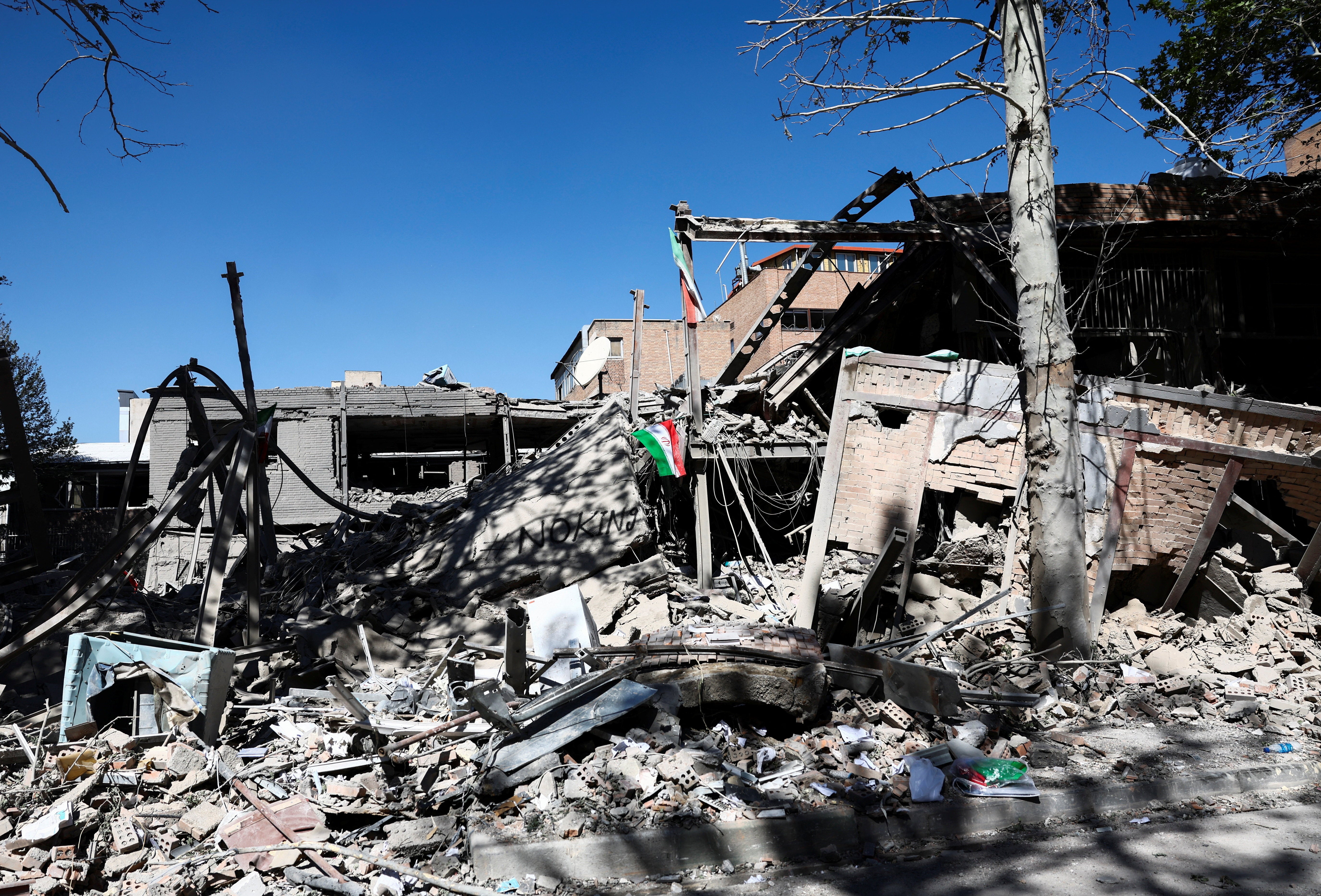 An Iranian flag lies amidst the rubble of a building of the Sharif University of Technology, which was damaged in a strike