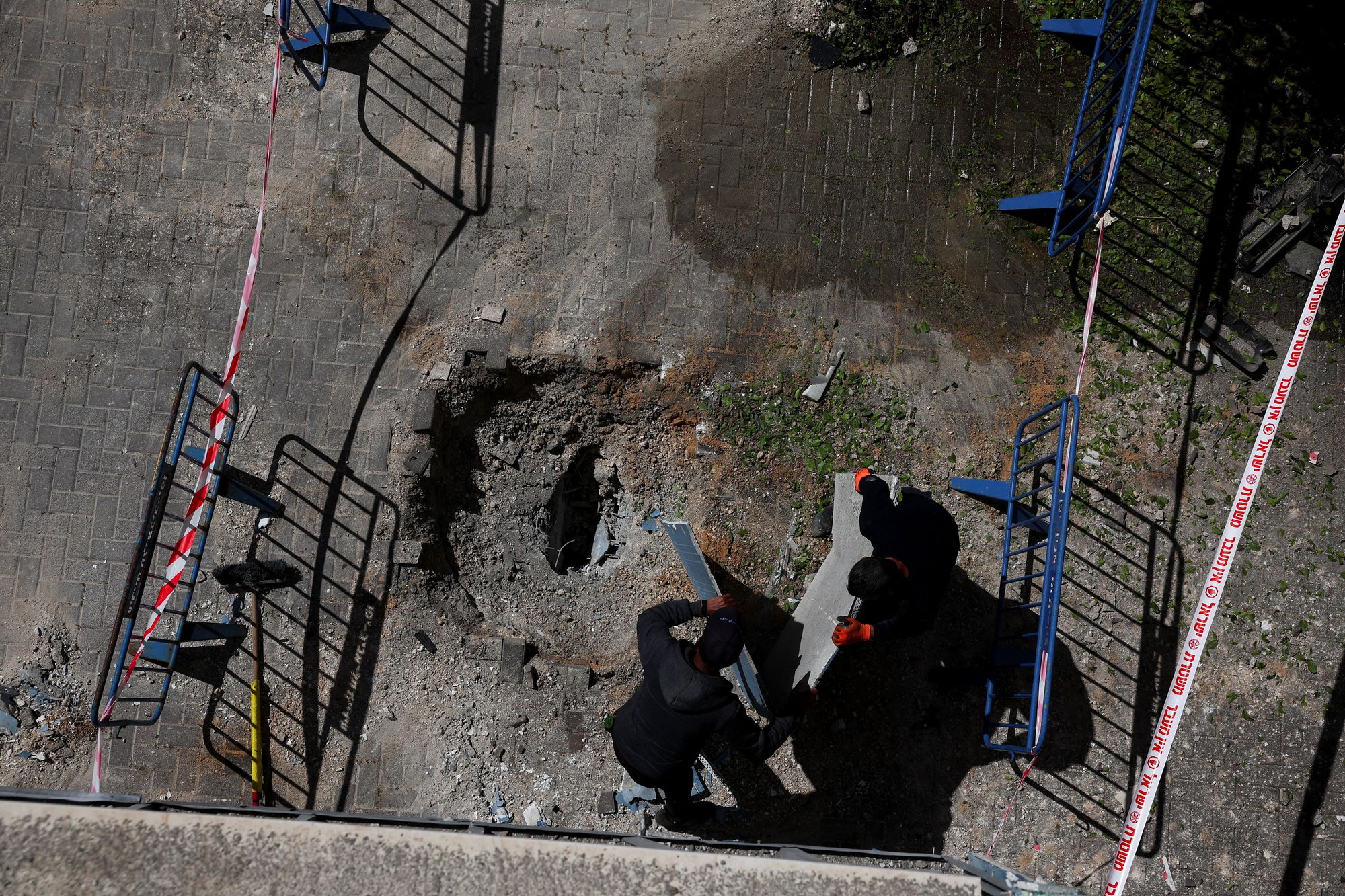 Emergency responders work at an impact site after a barrage of missiles was launched from Iran into Israel, amid the U.S.-Israel conflict with Iran, in central Israel on 7 April