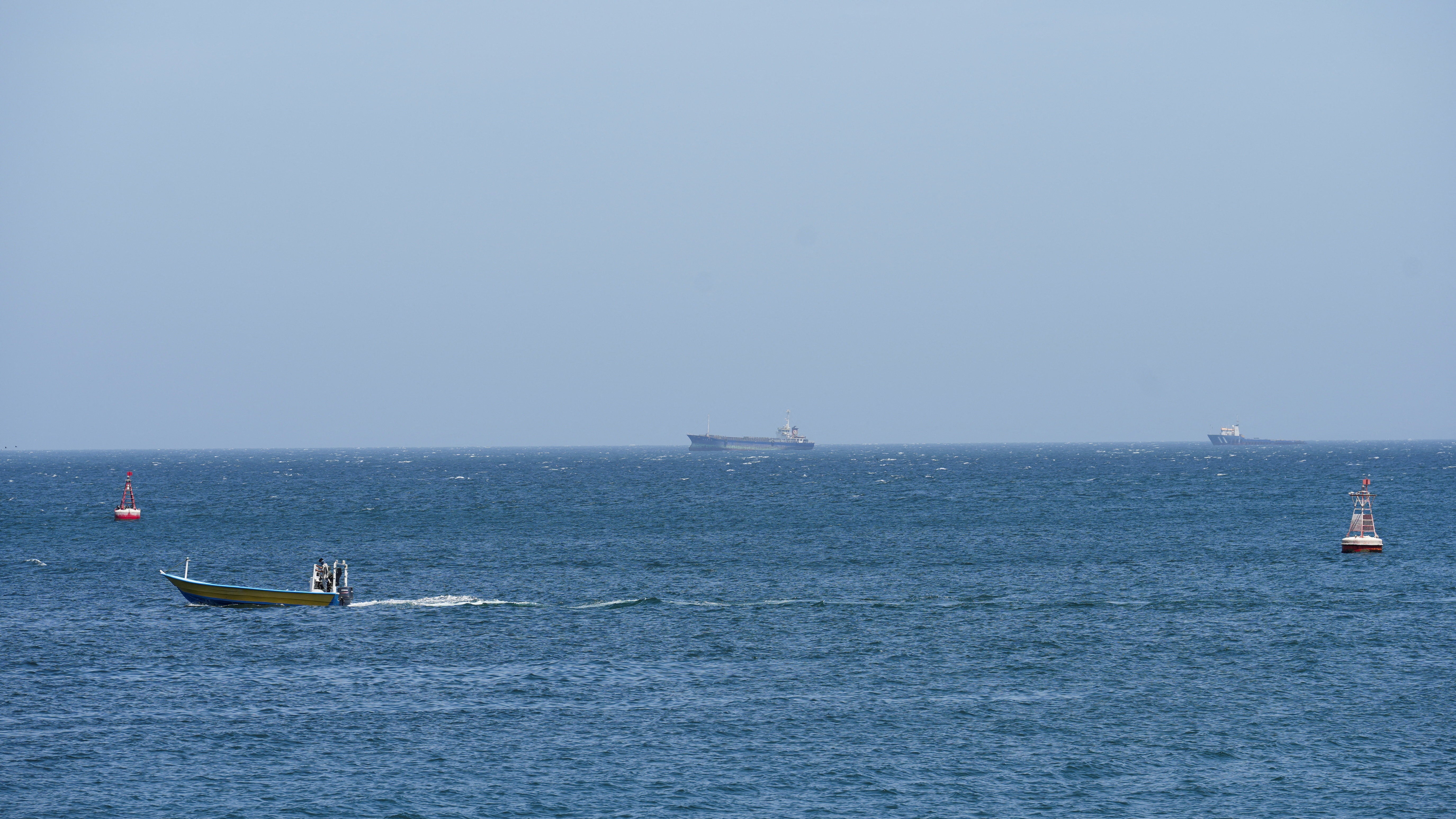 Vessels and boats are off the coast of Musandam governorate, overlooking the strait of Hormuz, in Musandam governance, in Oman, 8 April