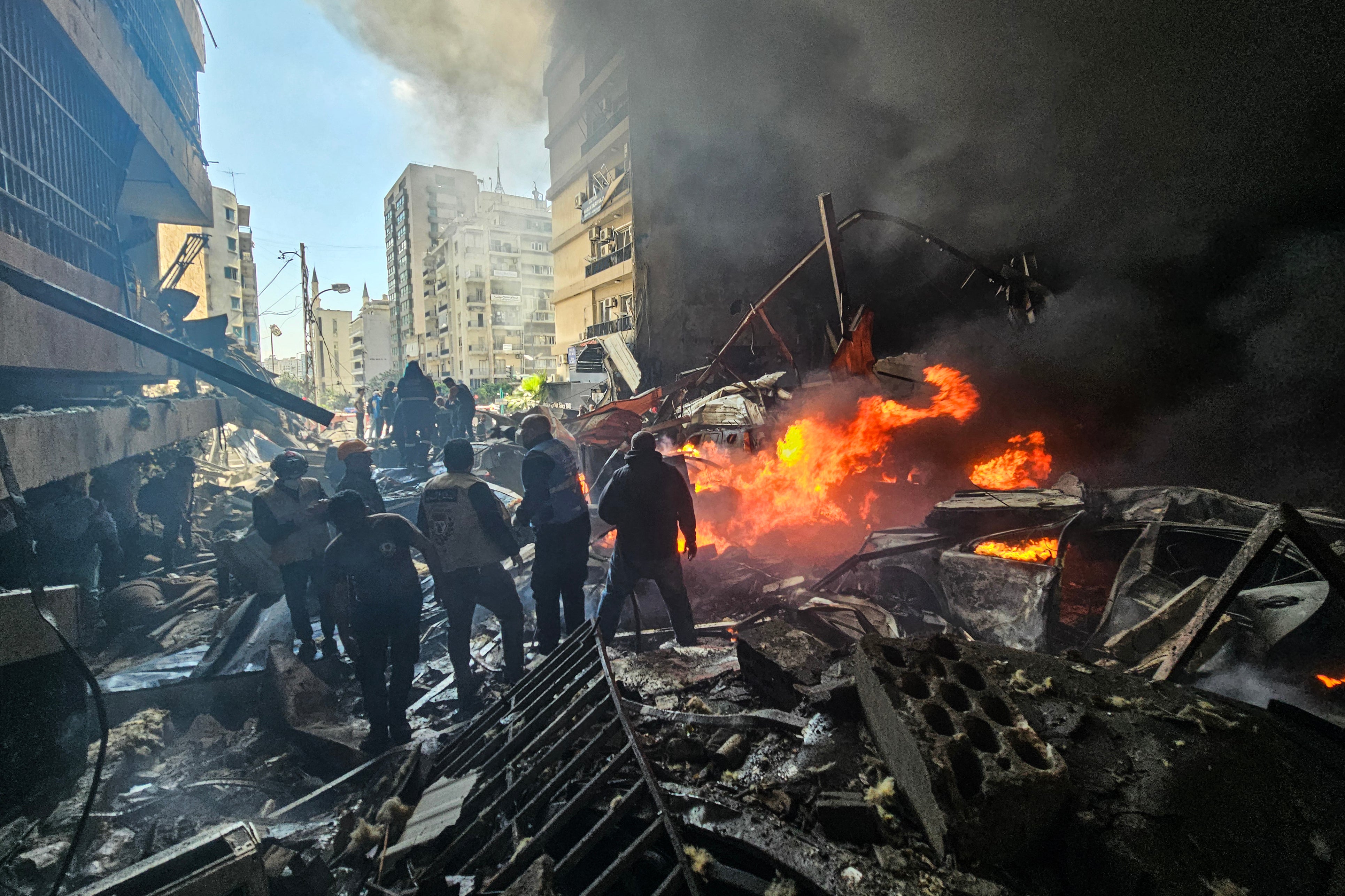 First responders stand amid rubble at the site of an Israeli airstrike in Beirut's Corniche al-Mazraa neighbourhood