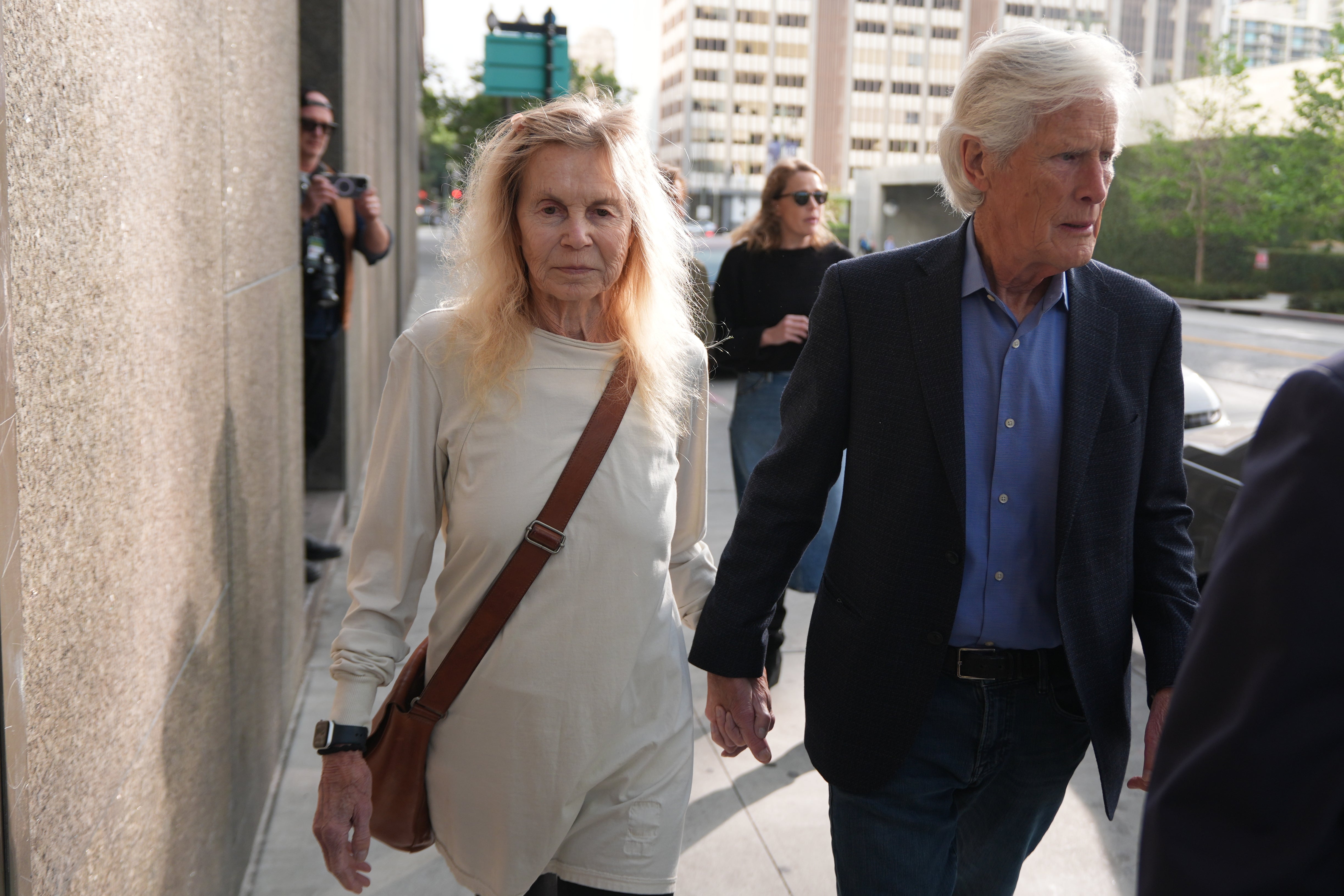 Suzanne Morrison, mother of Matthew Perry, walks into court with her husband Keith Morrison before Jasveen Sangha, who plead guilty to selling Perry a lethal dose of the drug ketamine in the days before his death, appears in court for sentencing on Wednesday, April 8, 2026 in Los Angeles. (AP Photo/Damian Dovarganes)