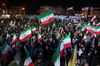 Iranians react after a ceasefire announcement is made at the Enqelab Square in Tehran