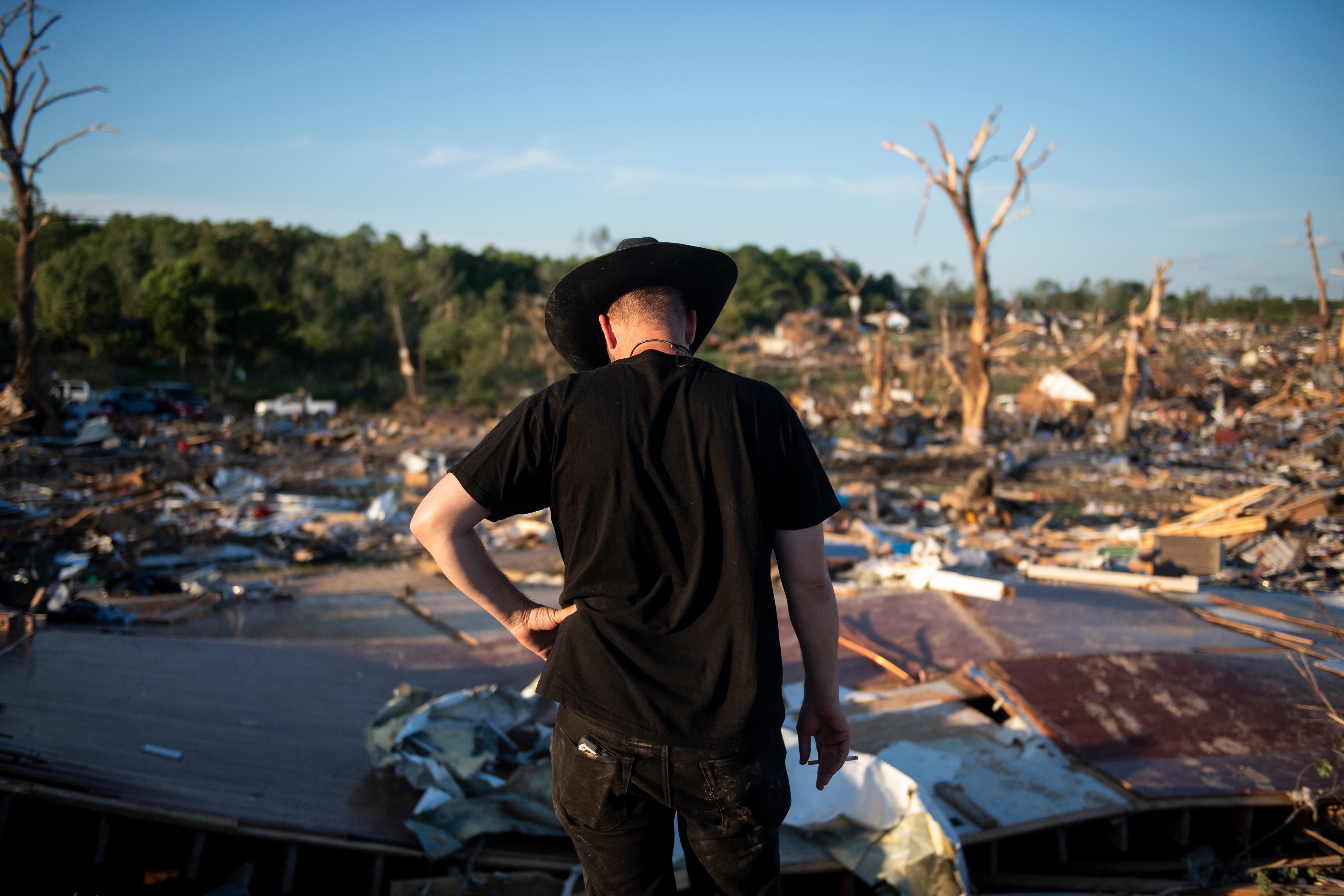 Tony McFall trägt den Cowboyhut seines Vaters, während er über die Trümmer des Hauses seines Vaters und seiner Stiefmutter blickt, die im vergangenen Mai bei einem Tornado in Sunshine Hills, Kentucky, ihr Leben verloren. Experten sagen, dass Menschen, die Tornadowarnungen hören, sofort Schutz suchen sollten