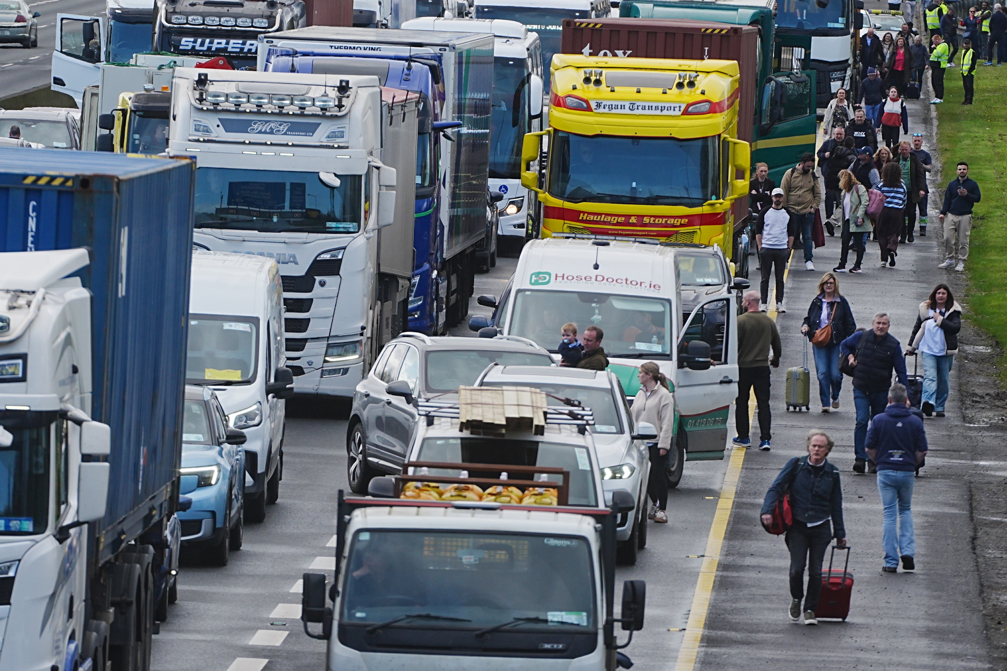 People with their luggage walk past the heavy traffic on Dublin’s M50 Northbound