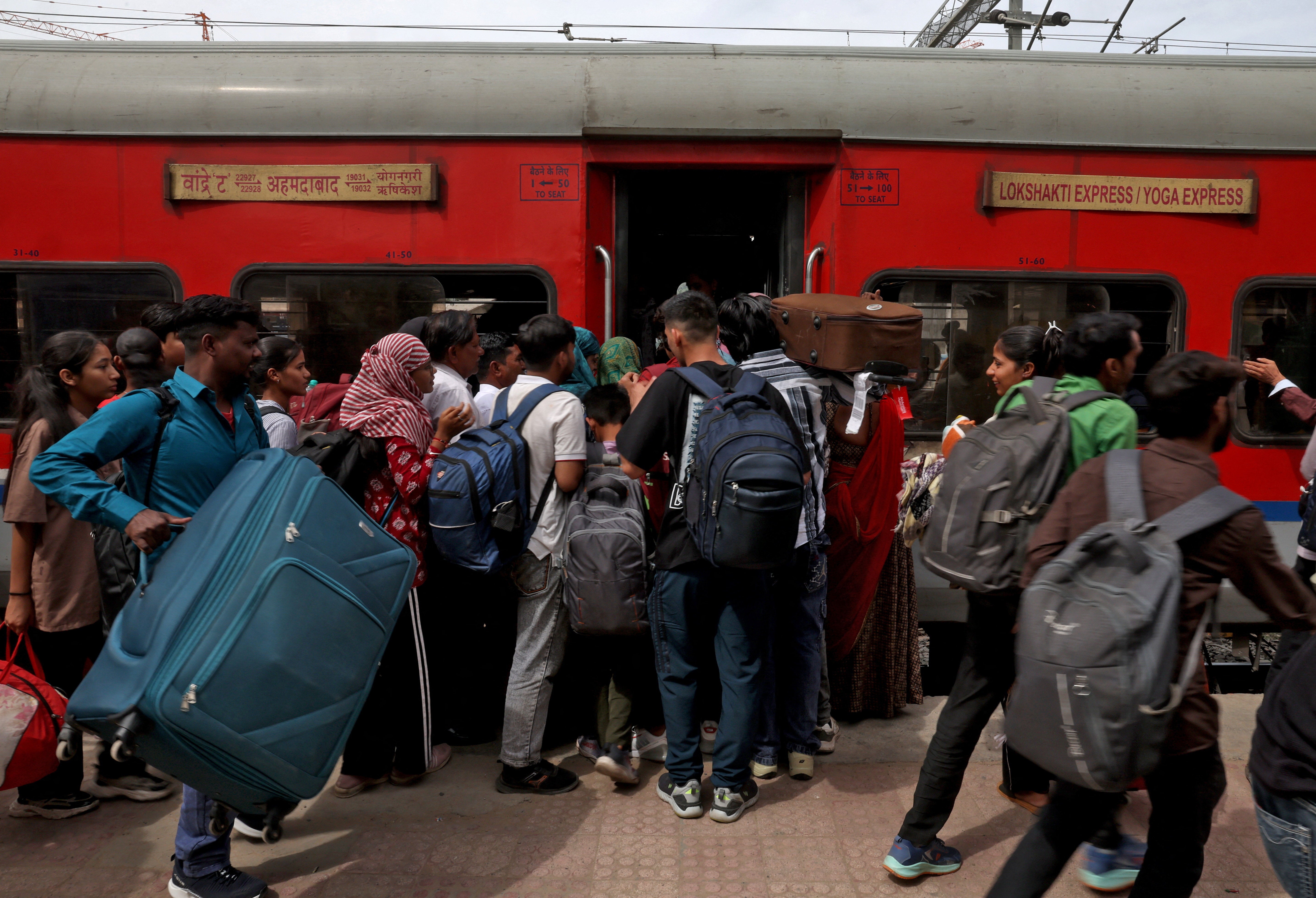 Passengers, including migrant labourers and their families, board a train in New Delhi