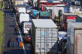 People with their luggage walk past the heavy traffic on Dublin’s M50 Northbound (Brian Lawless/PA)