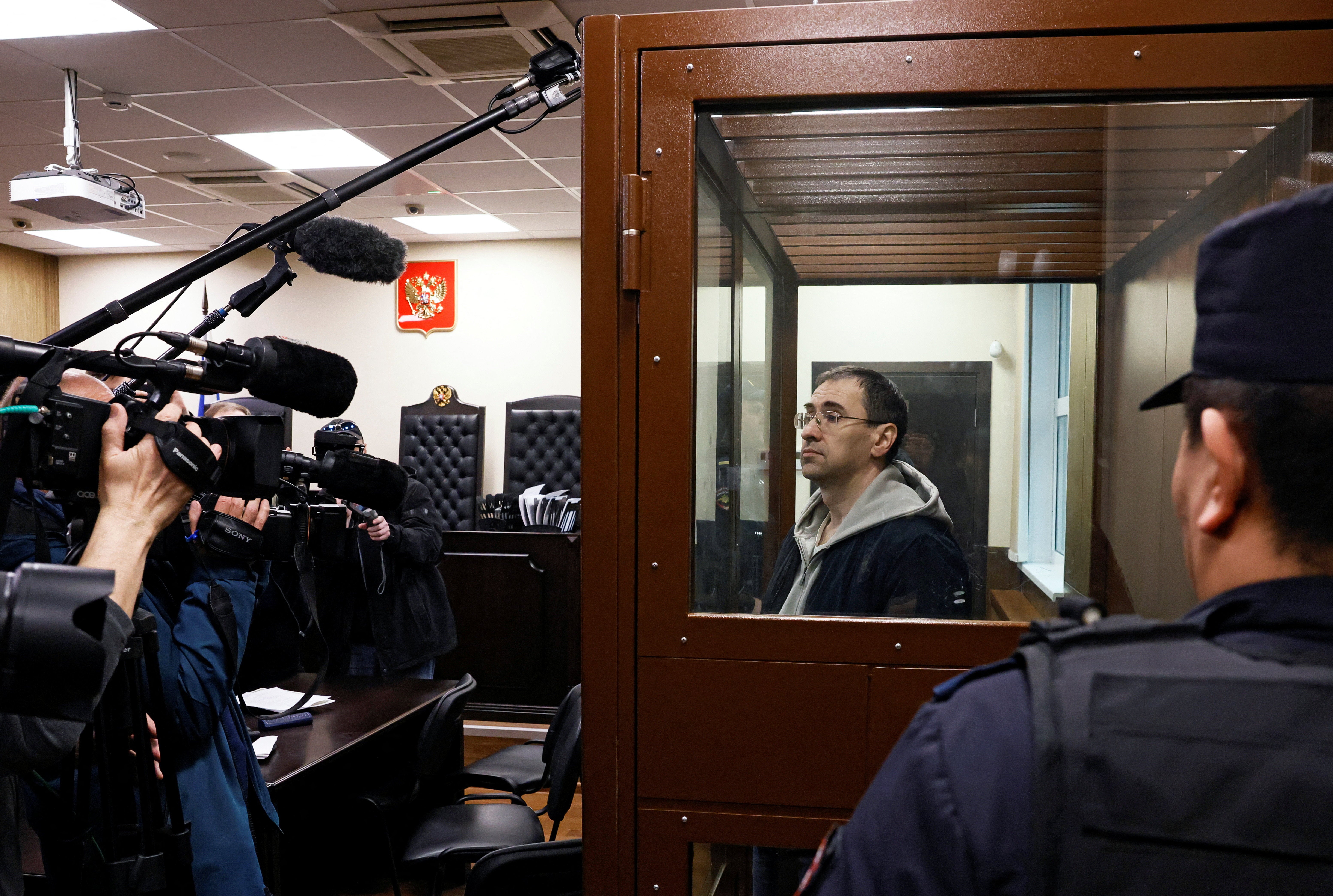 Oleg Roldugin stands inside an enclosure for defendants before a court hearing in Moscow, Russia April 10