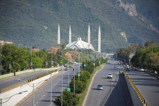 People commute on a road near Faisal Mosque, as Pakistan prepares to host the U.S. and Iran for peace talks, in Islamabad, Pakistan