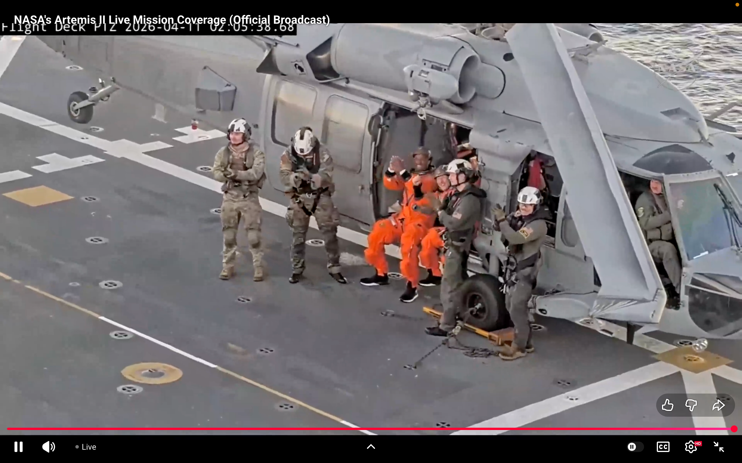 Artemis II astronauts Victor Glover and Christina Koch wave and salute to the camera after safely landing on the USS John P. Murtha following their return from lunar space