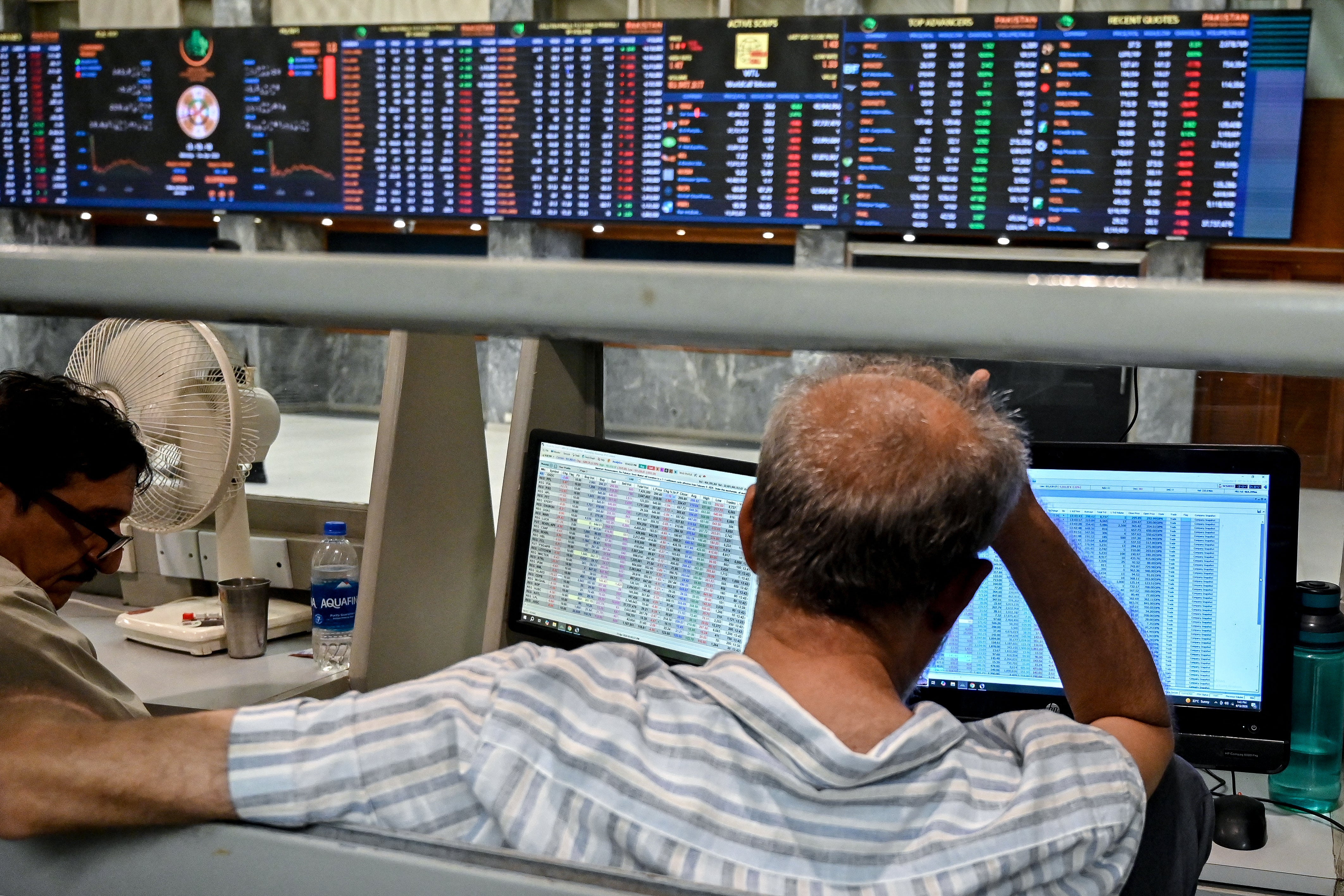Stockbrokers react during trading hours at the Pakistan Stock Exchange (PSX) in Karachi on April 13