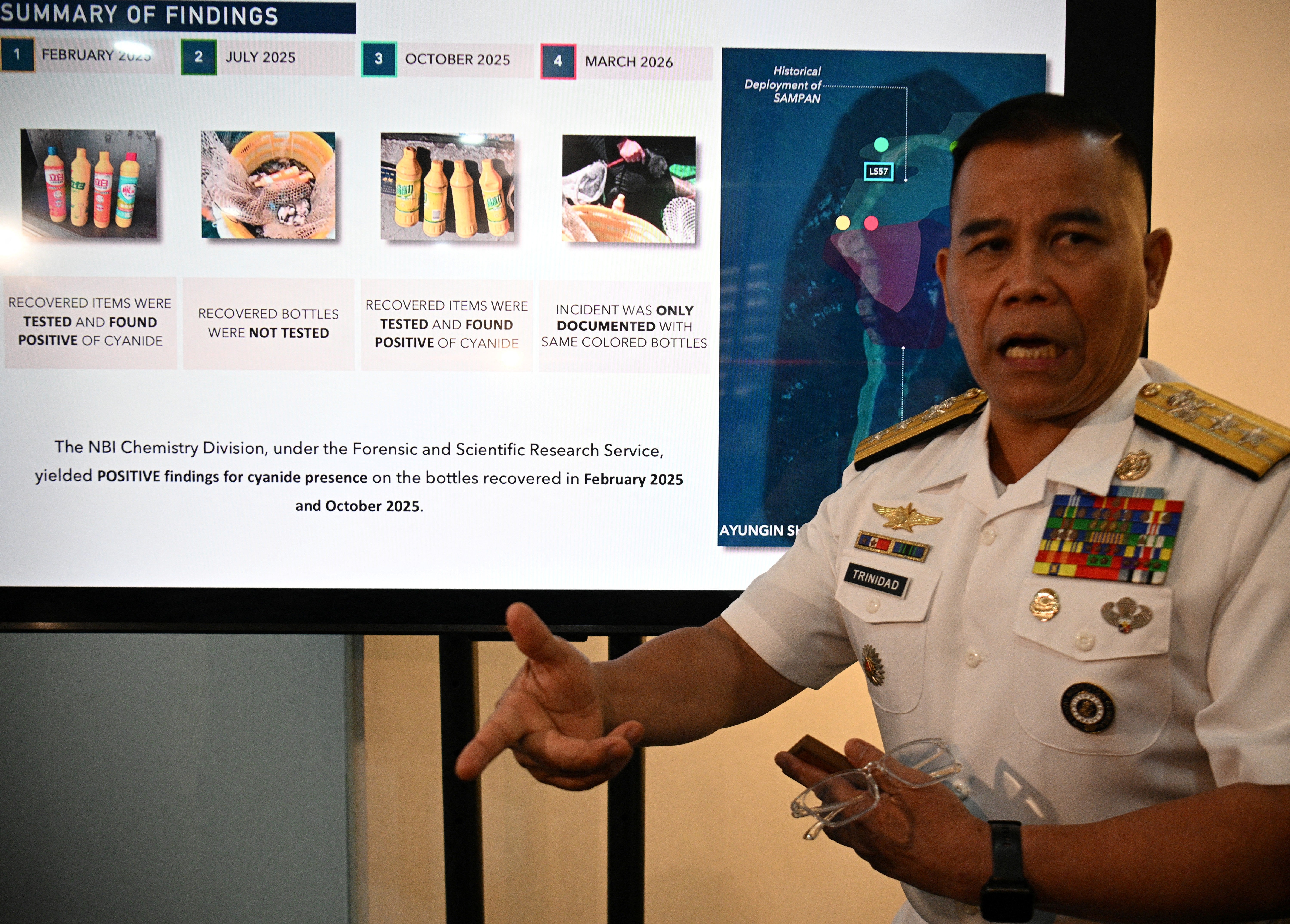 Philippine Navy spokesman Rear Admiral Roy Vincent Trinidad speaks next to a slide presentation of seized yellow bottles suspected to contain cyanide in waters of Second Thomas Shoal in the disputed South China Sea, during a press conference in Manila