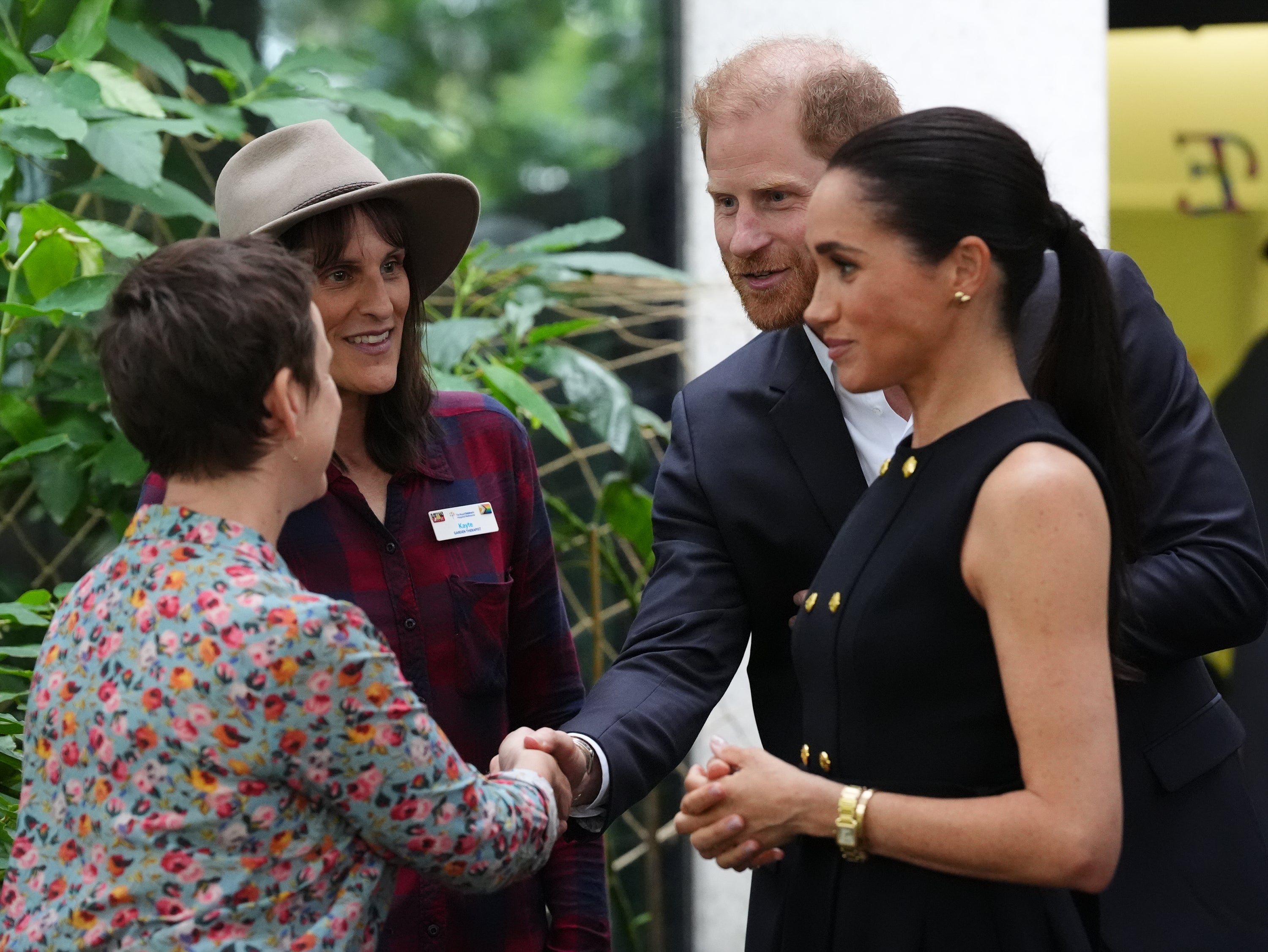 Britain's Prince Harry and Meghan Markle, the Duke and Duchess of Sussex, meet garden therapists Amelia and Kayte in the Kelpie garden during a visit to the Royal Children's Hospital Melbourne, Australia Tuesday, April 14, 2026. (Jonathan Brady/Pool Photo via AP)