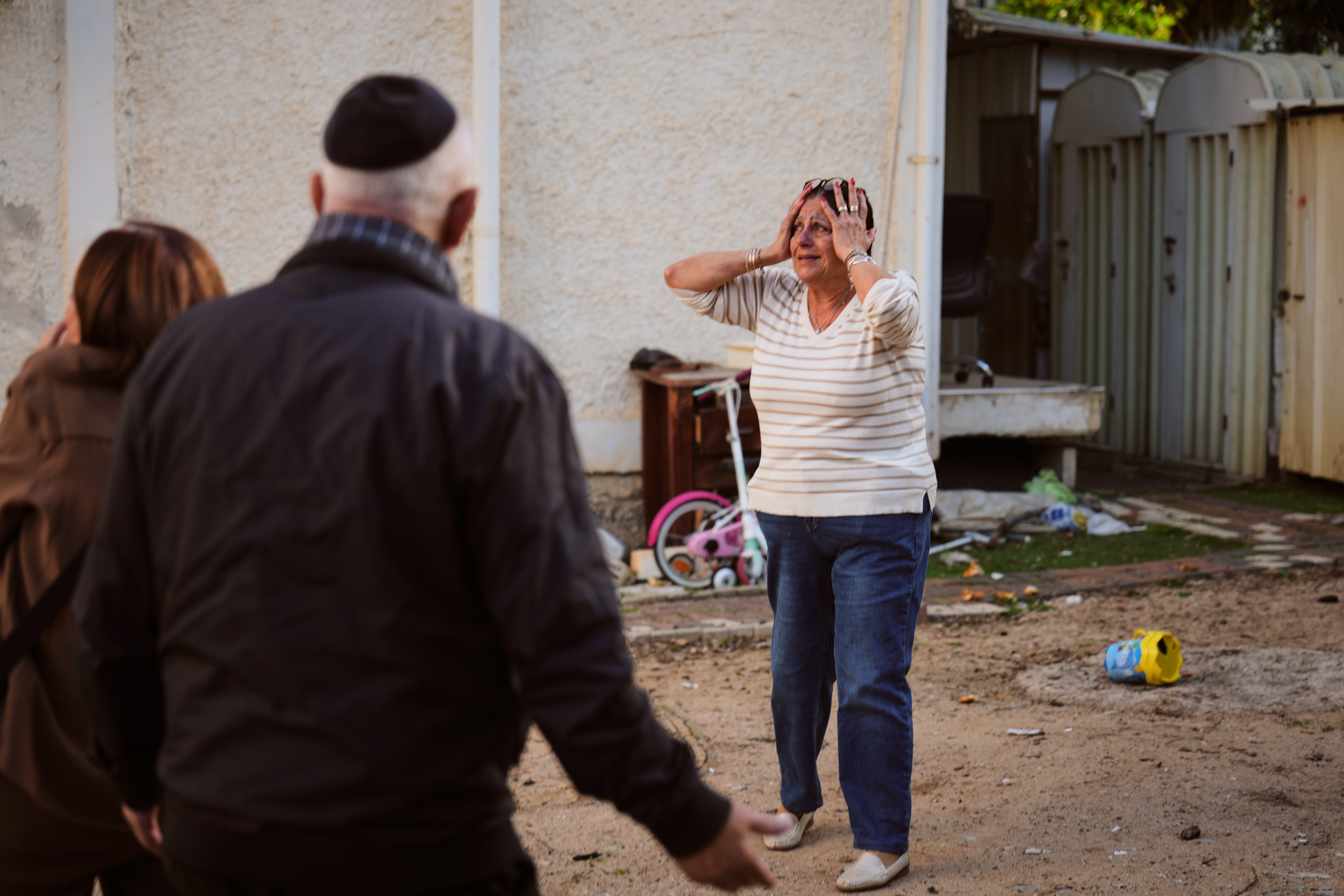 A woman reacts at the site of a damaged residential building after it was struck by a projectile fired from Lebanon.