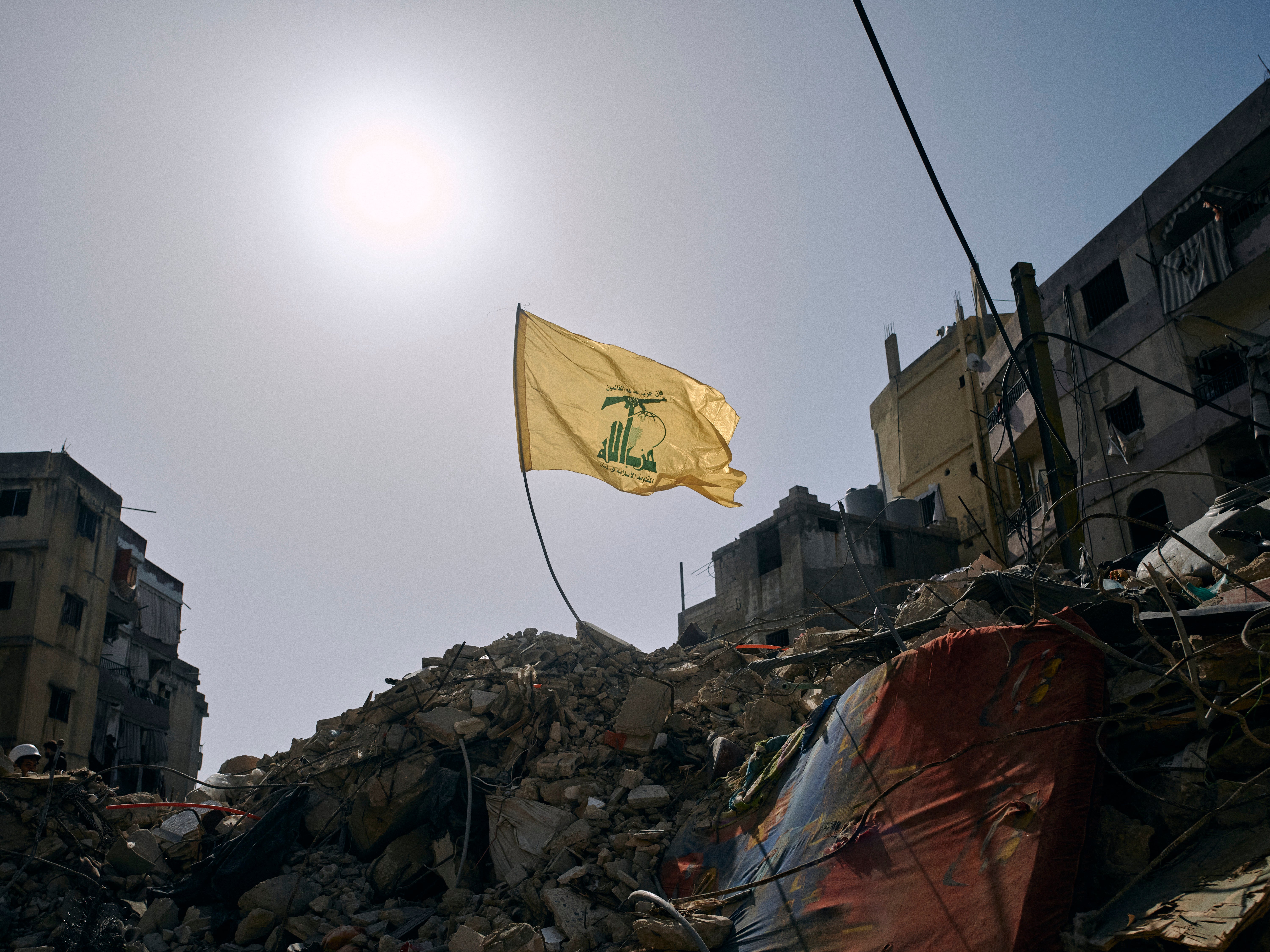 A Hezbollah flag flies over the ruins of an Israeli airstrike in the southern Beirut suburb of Dahiye al-Salam on 13 April