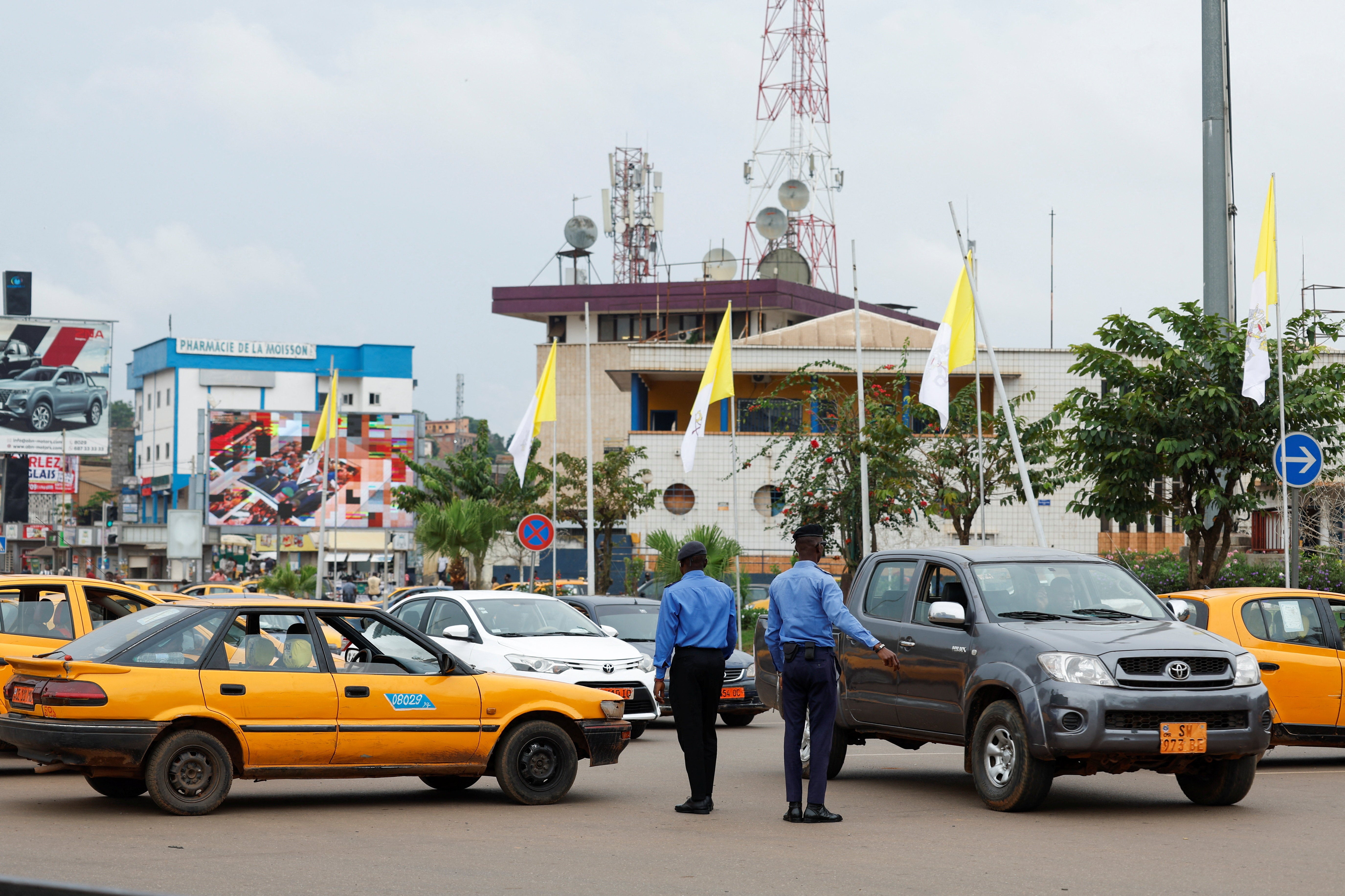Police officers direct traffic on a street ahead of Pope Leo XIV's visit, in Yaounde, Cameroon