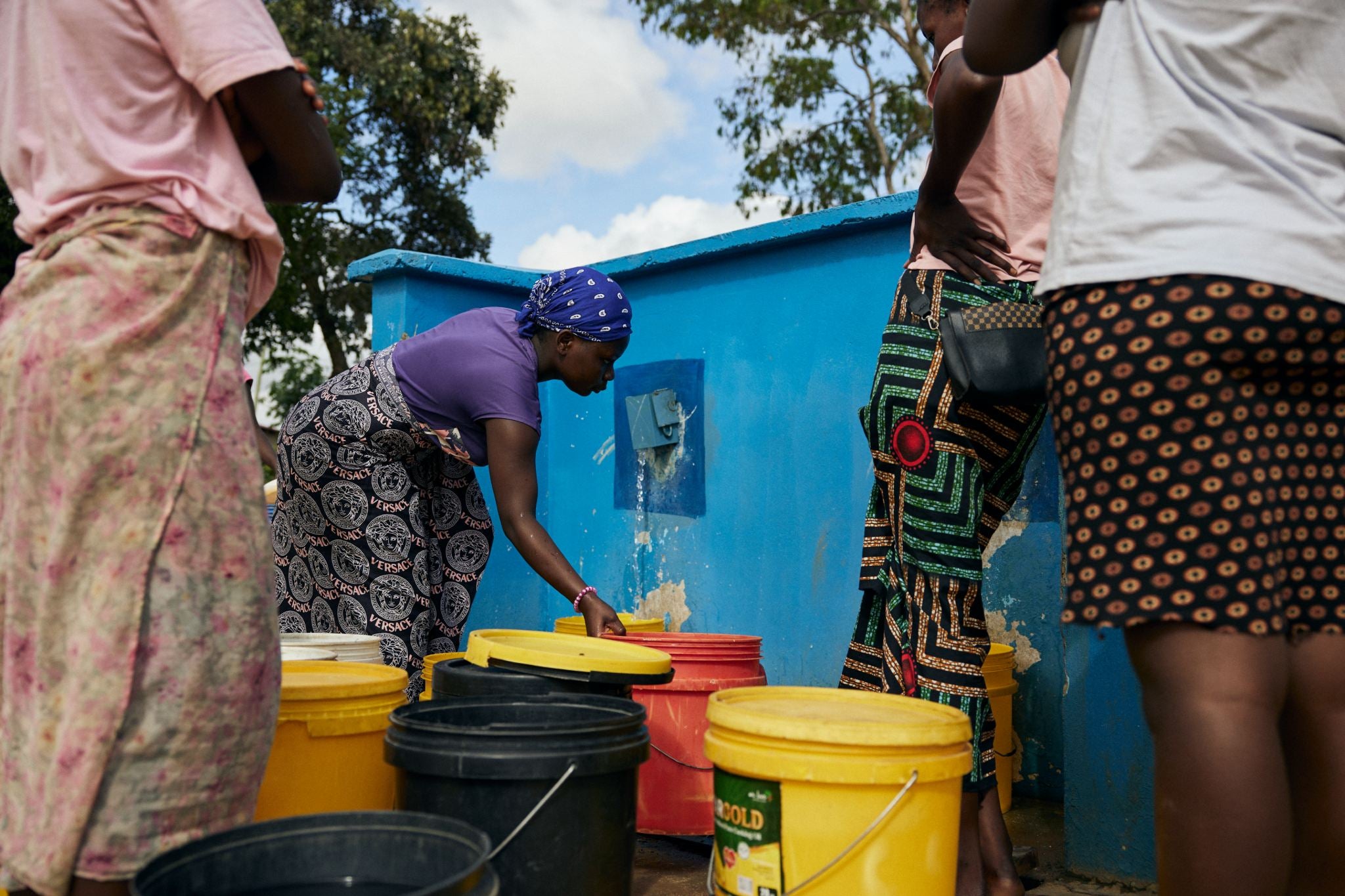 Miriam Nyirenda, middle, collects water from a water kiosk in Sylvia Masebo Community, Lusaka, Zambia
