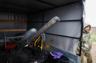 Ukrainian service member Anatolii stands next to an AS3 interceptor unmanned aerial vehicle, during training in Ukraine on April 10