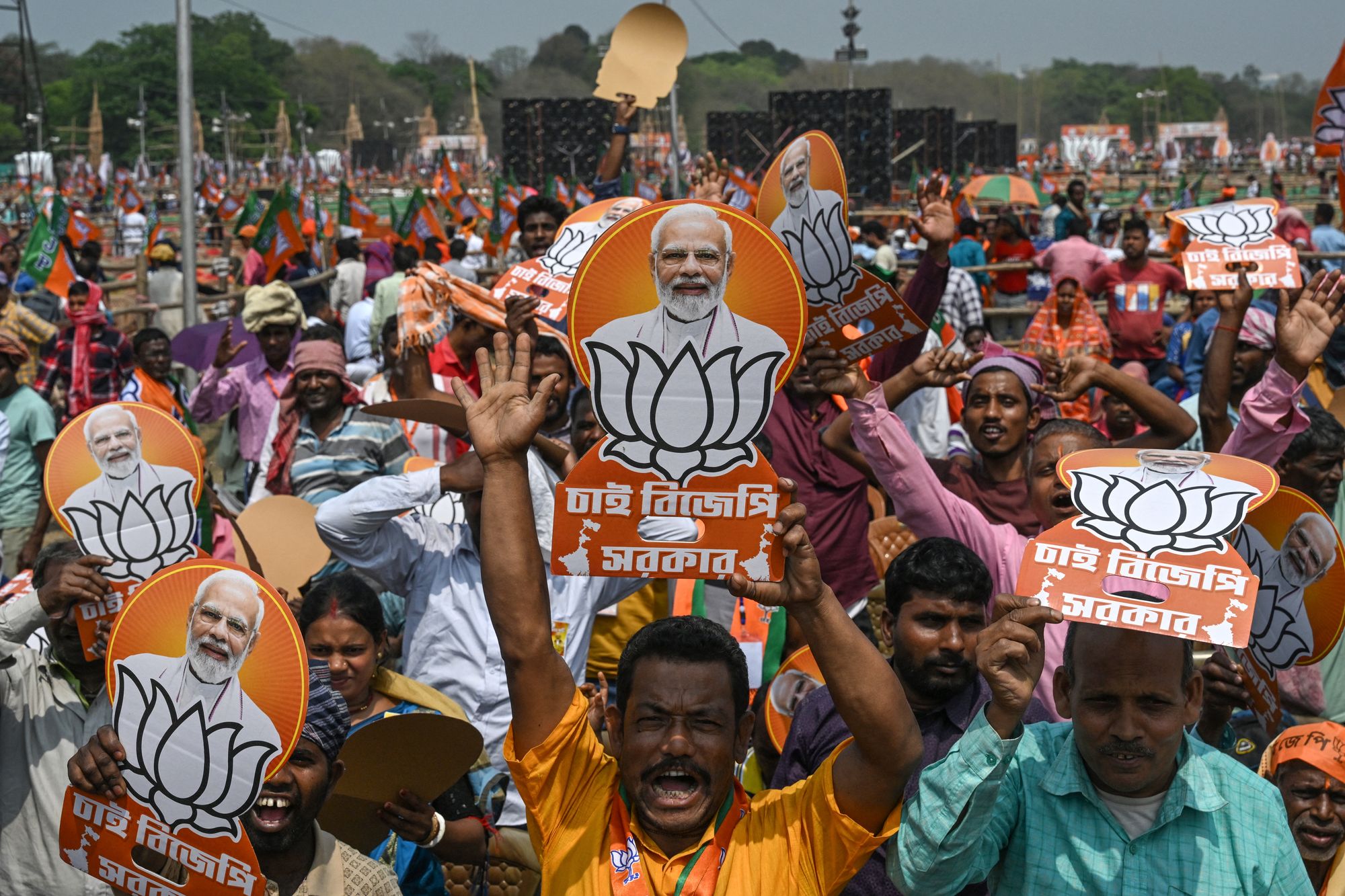 Bharatiya Janata Party (BJP) supporters holding posters of India's prime minister Narendra Modi attend a mass rally in Kolkata on 14 March 2026