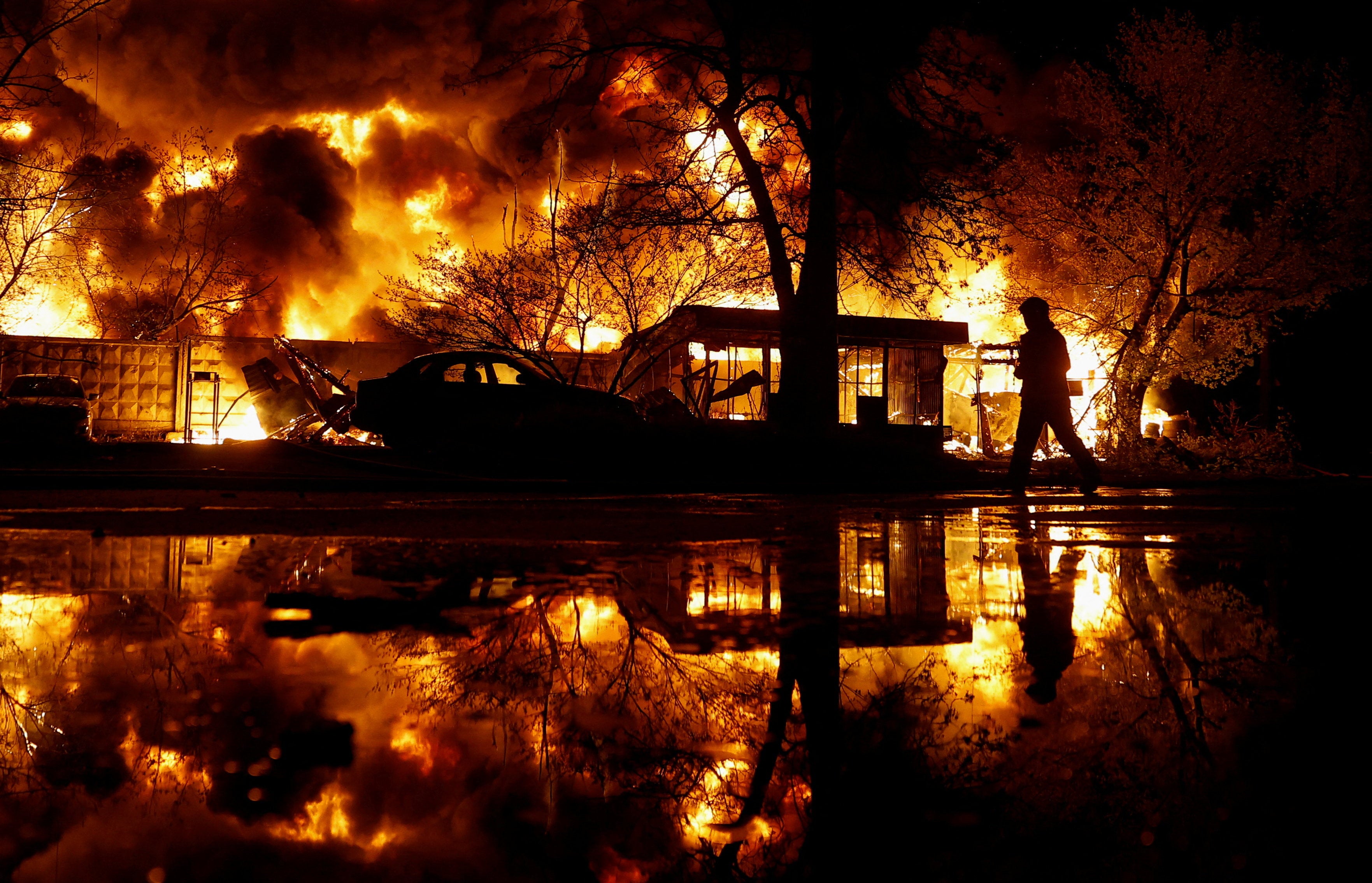 A firefighter works at the site of recycling materials hit by a Russian missile strike in Kyiv
